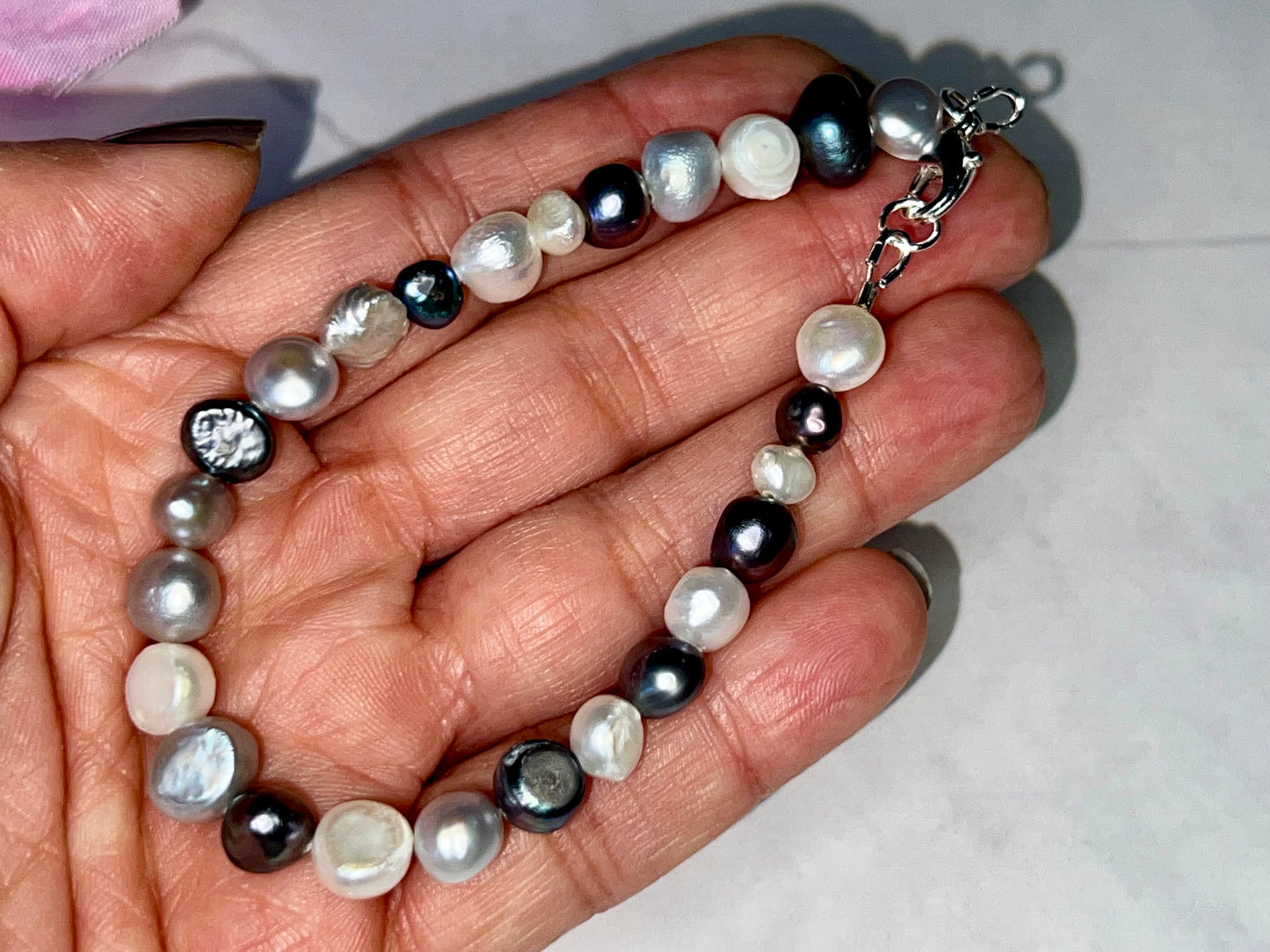 a person holding a necklace with pearls on it