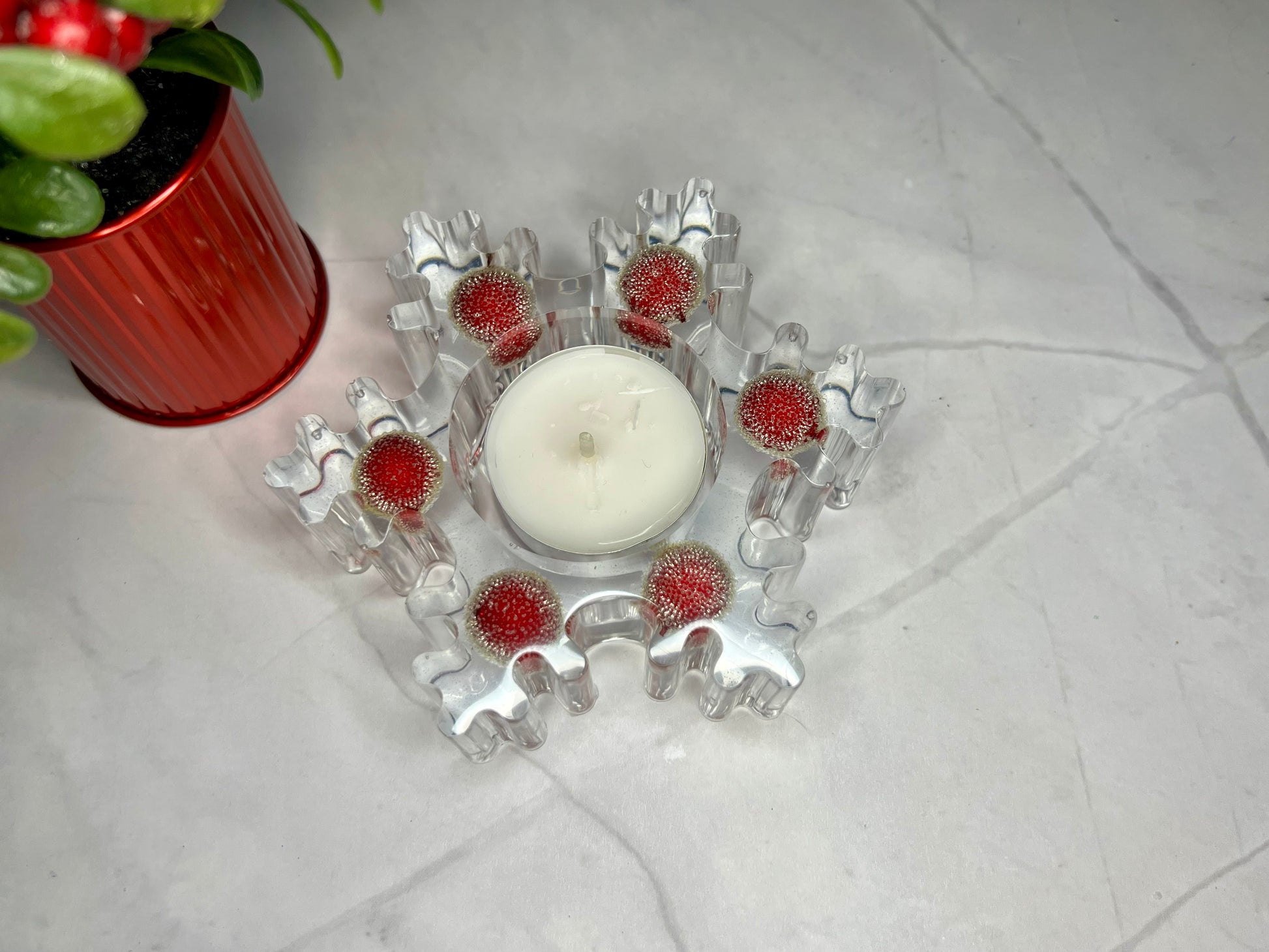 a candle sits on a table next to a potted plant