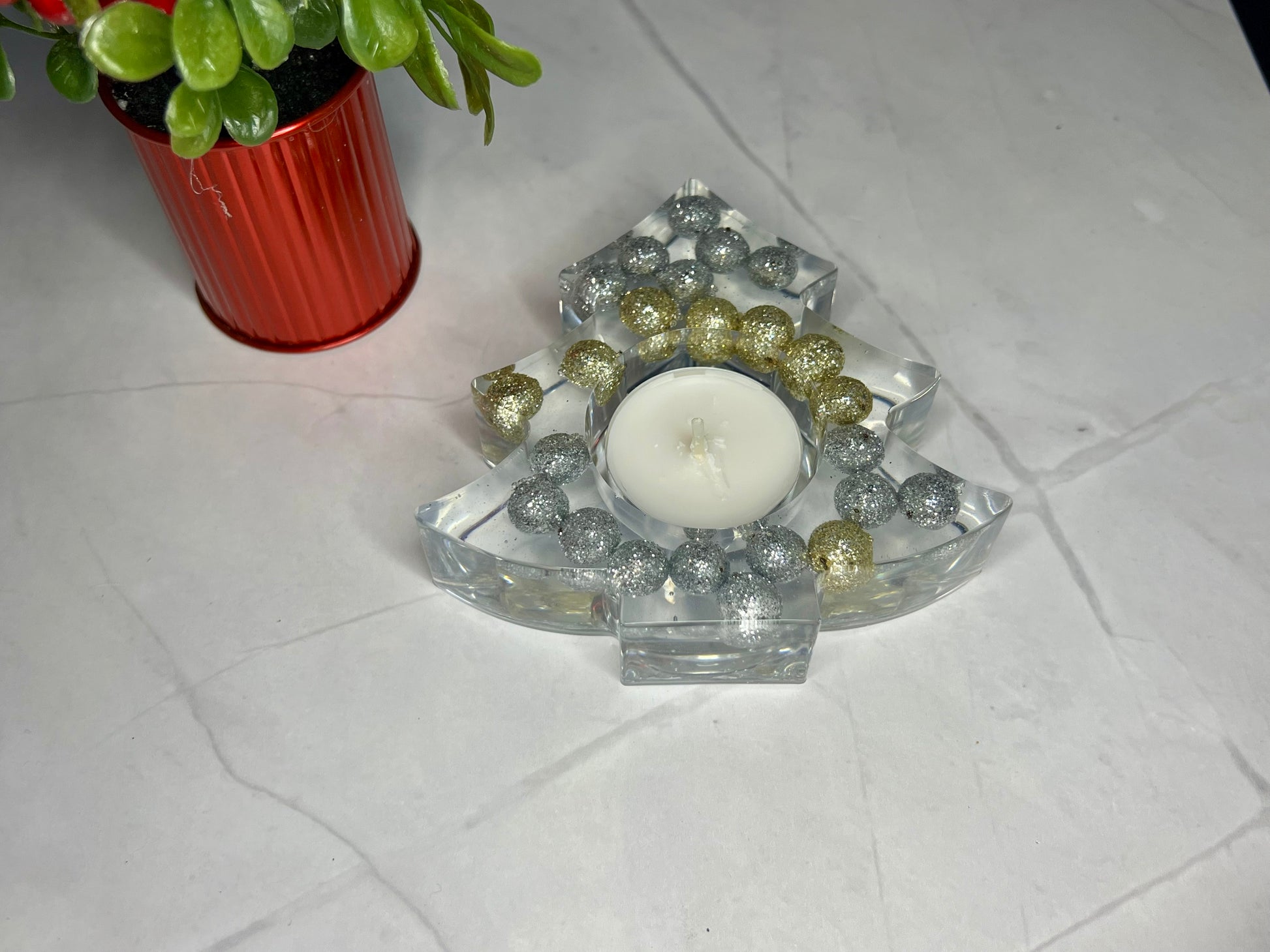 a candle sitting on top of a table next to a potted plant