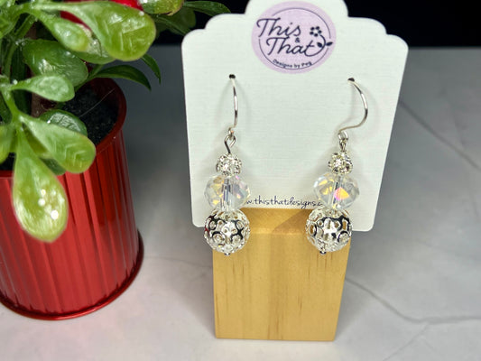 a pair of earrings sitting next to a potted plant