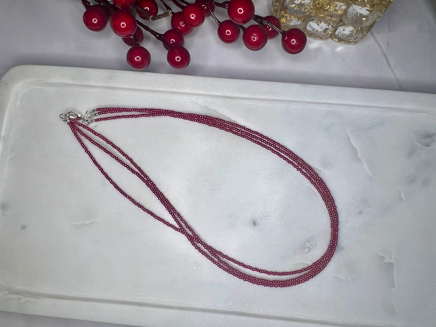 a white tray with a red necklace on it