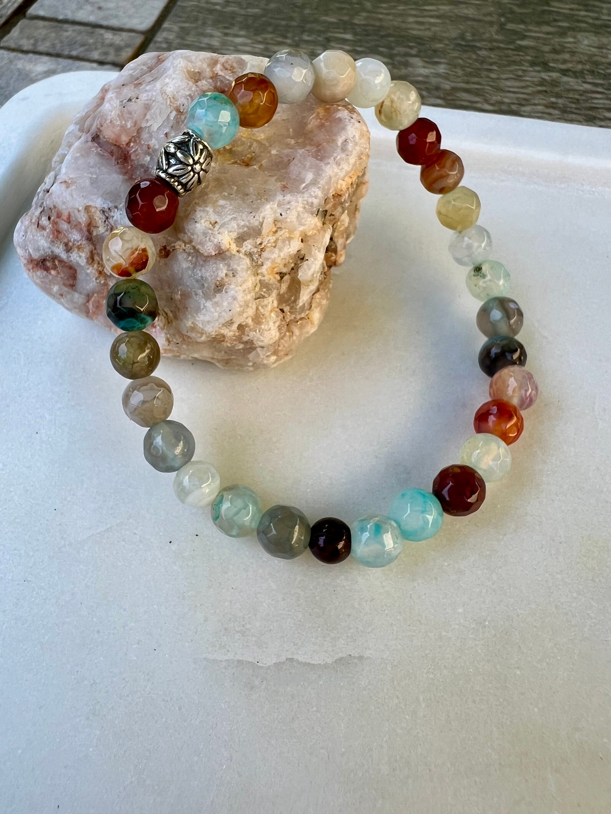 a beaded bracelet sitting on top of a rock