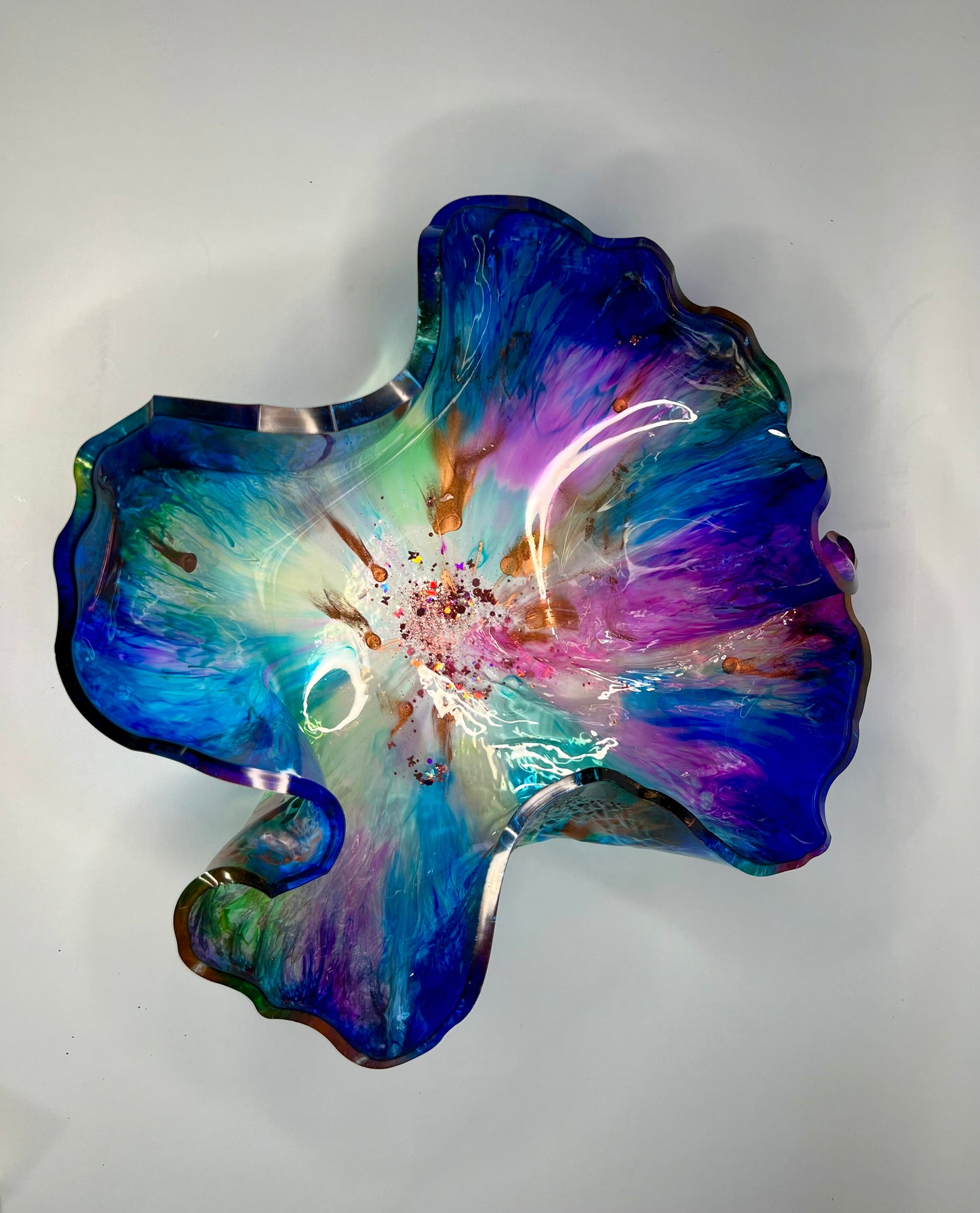 a blue and purple flower shaped dish on a white surface