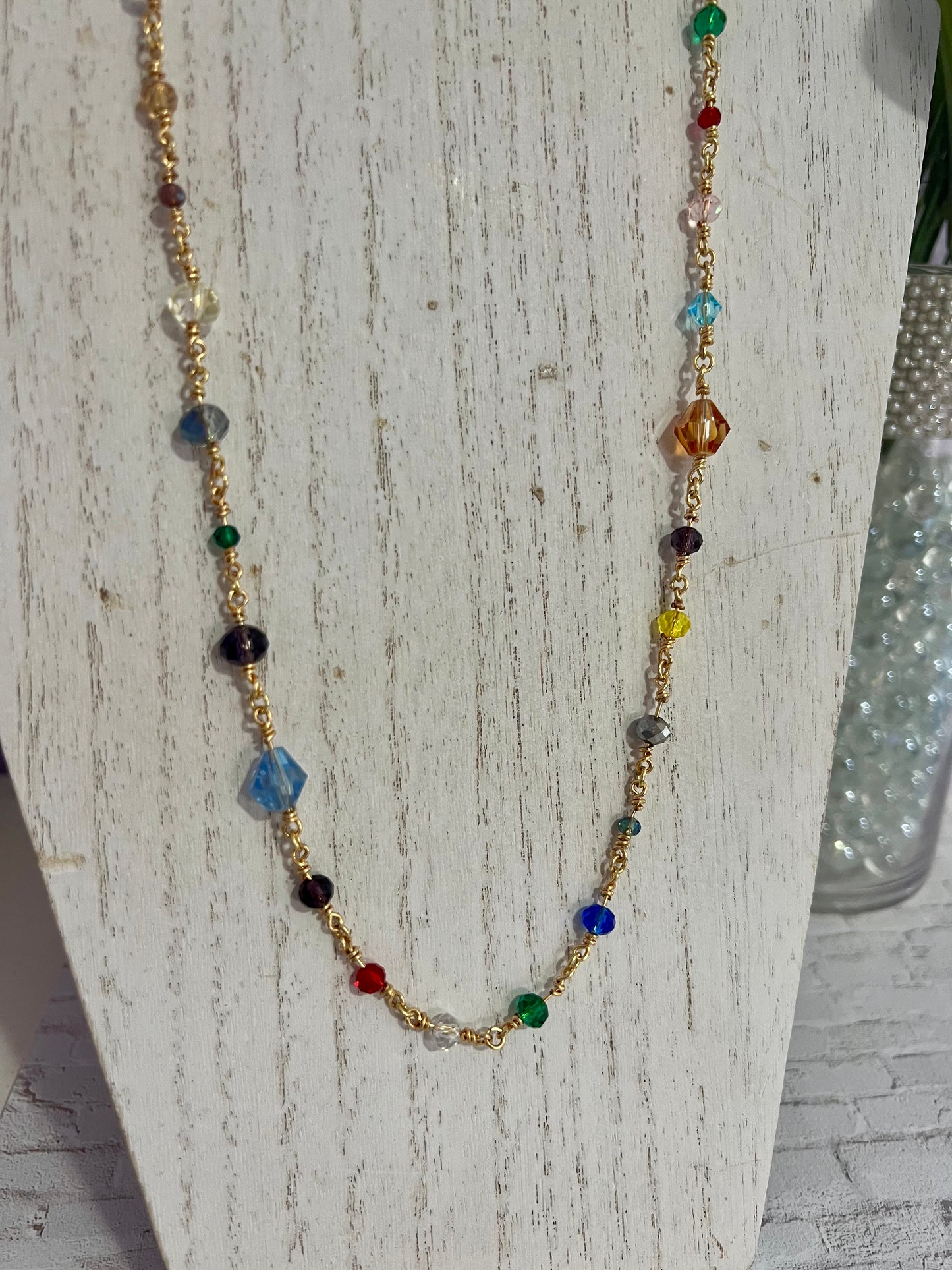 a necklace with multicolored beads and a gold chain