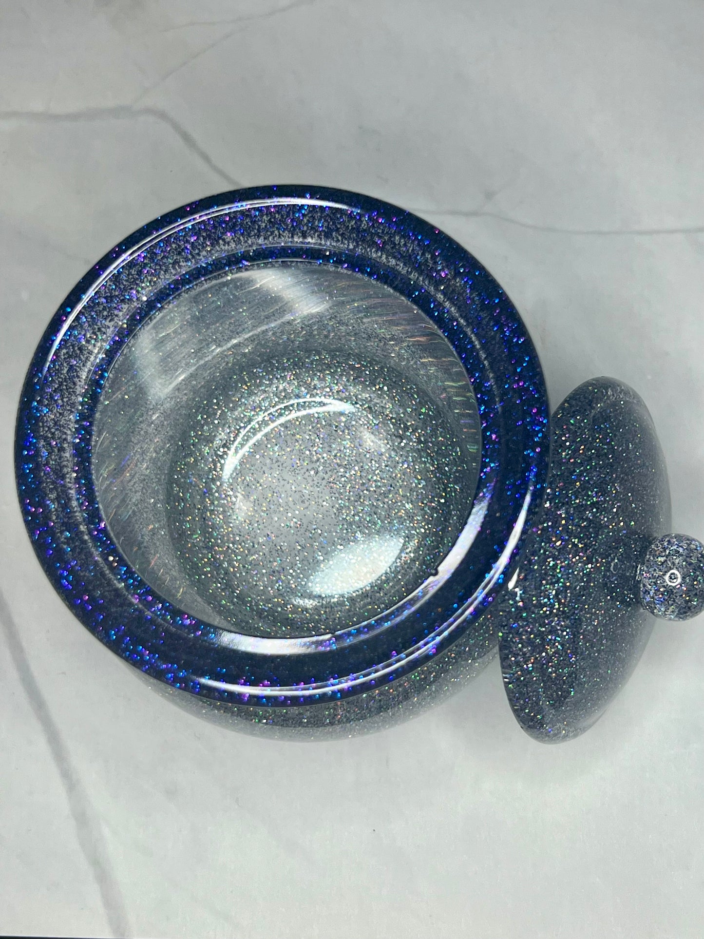 a blue glass bowl with a lid on a white table