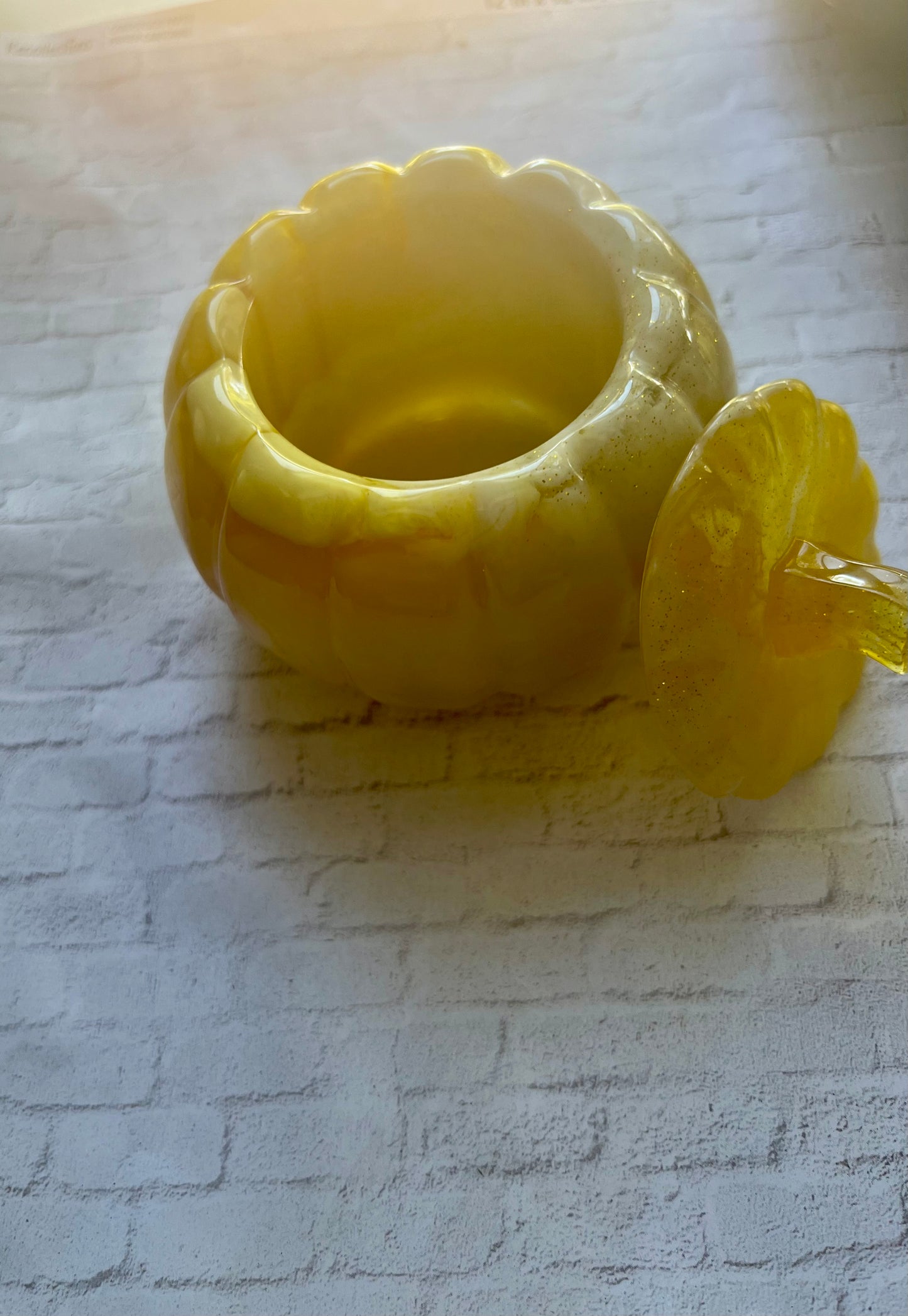 a yellow vase sitting on top of a white brick wall