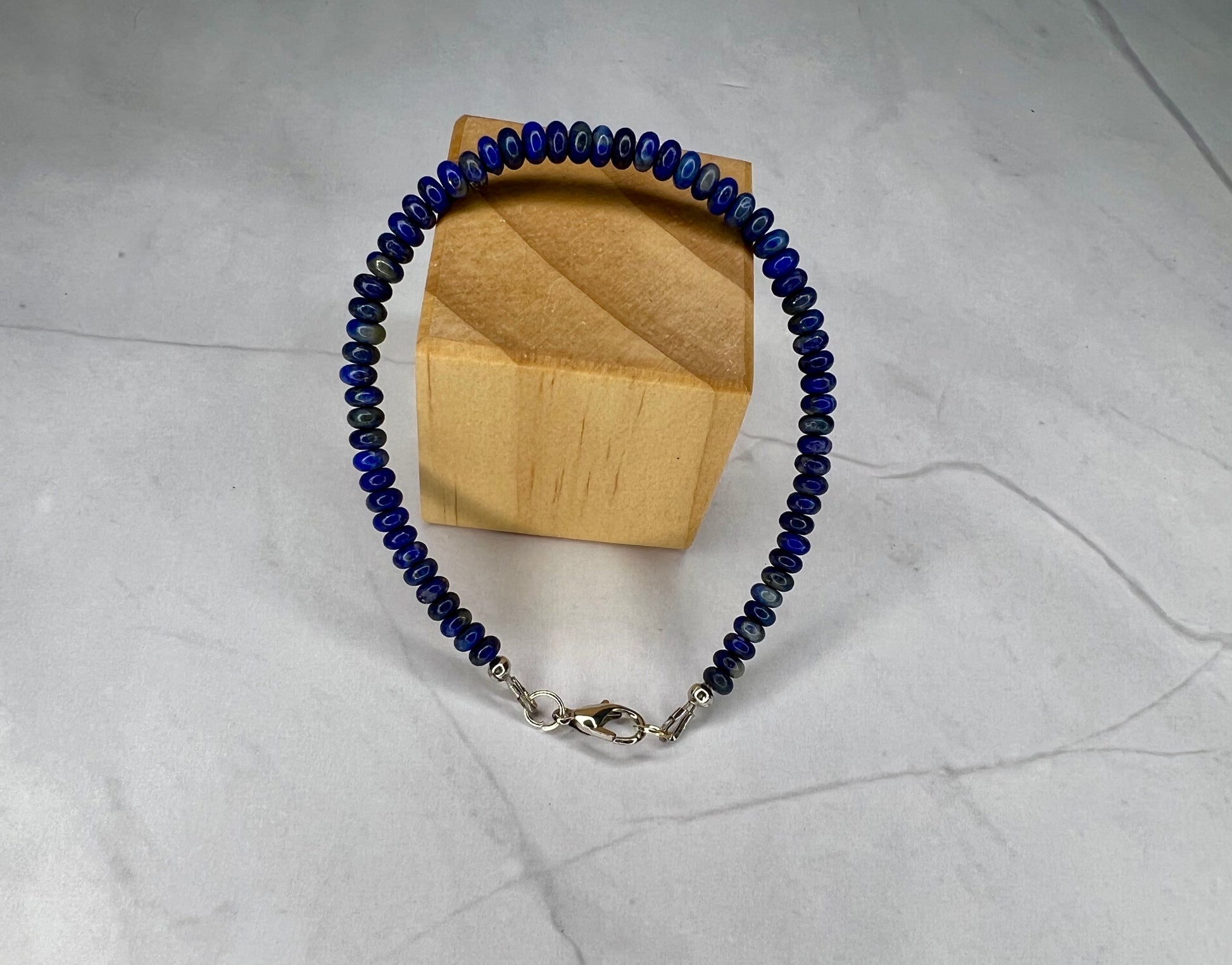 a blue beaded bracelet with a wooden box