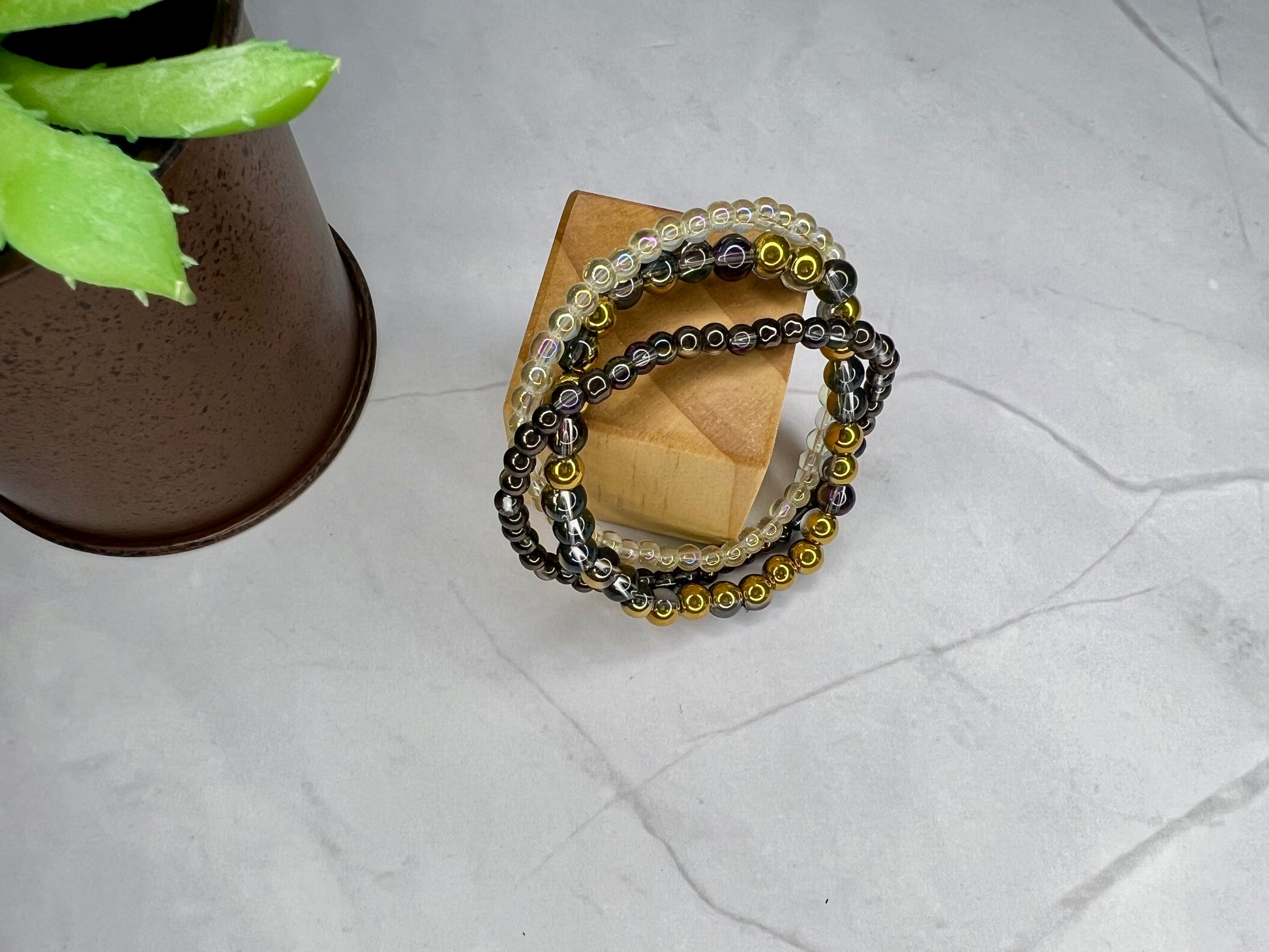 a stack of bracelets sitting next to a potted plant