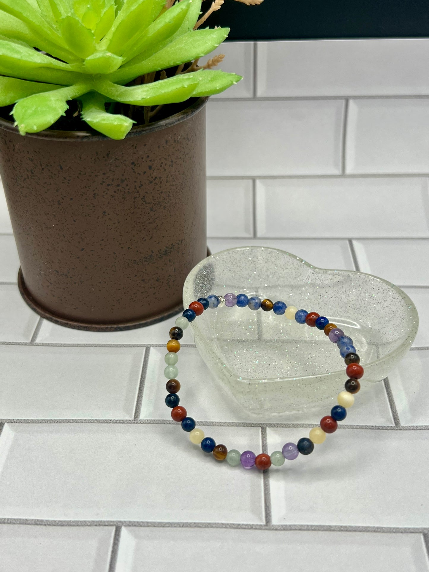 a glass bracelet sitting next to a potted plant