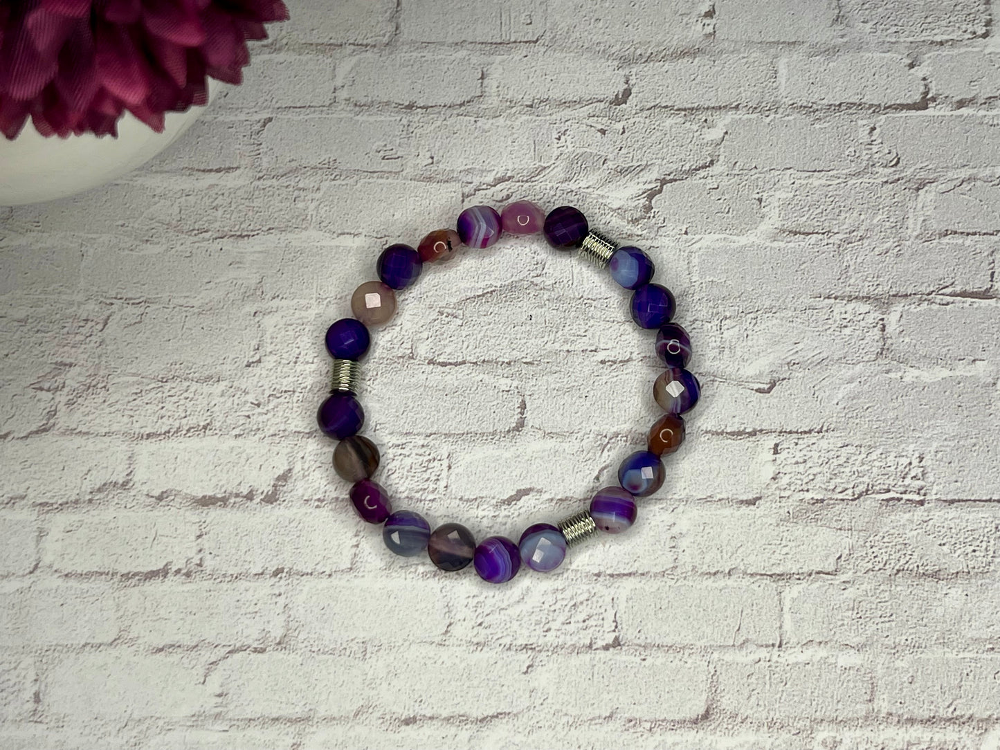 a bracelet made of glass beads on a brick wall