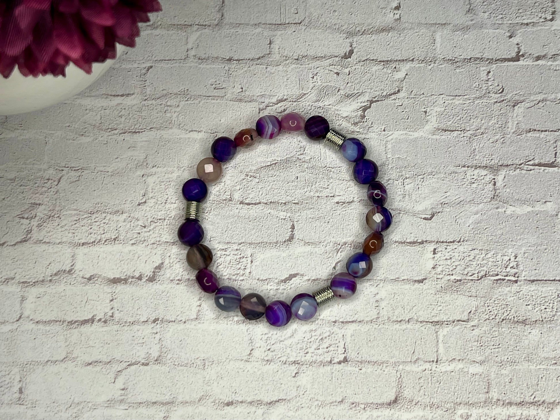 a bracelet made of glass beads on a brick wall