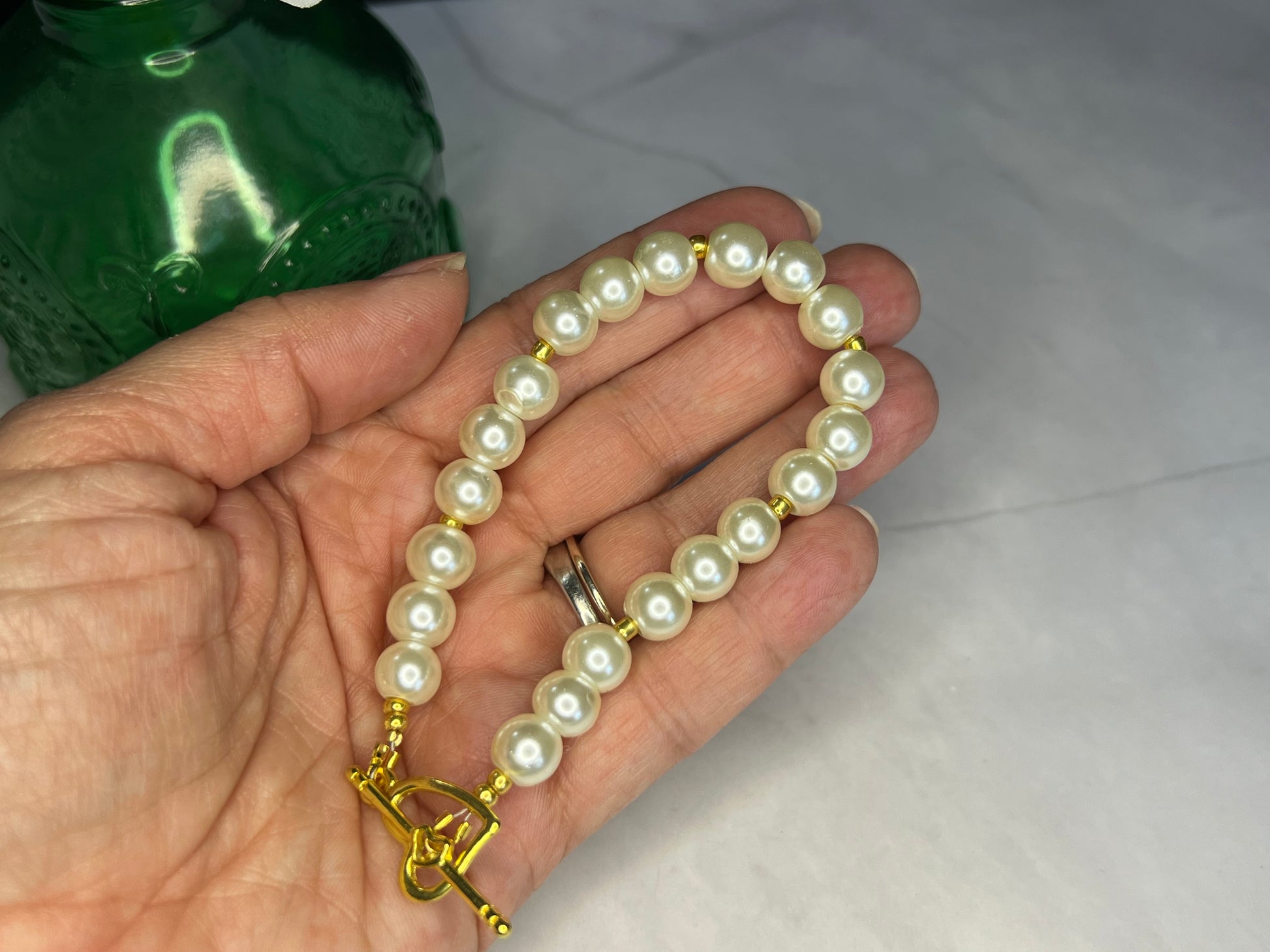 a person holding a pearl necklace in their hand