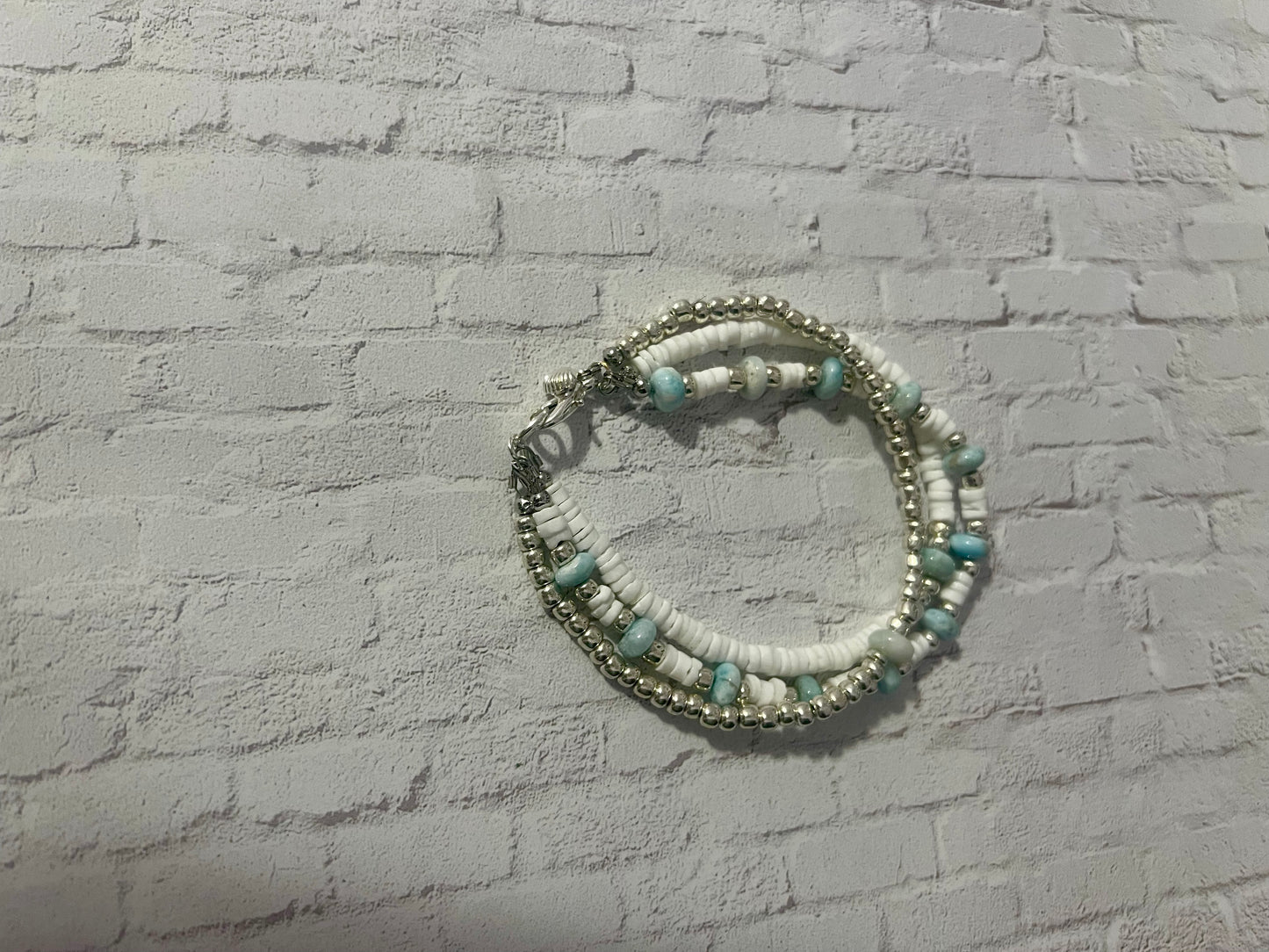 a white brick wall with a bracelet hanging on it