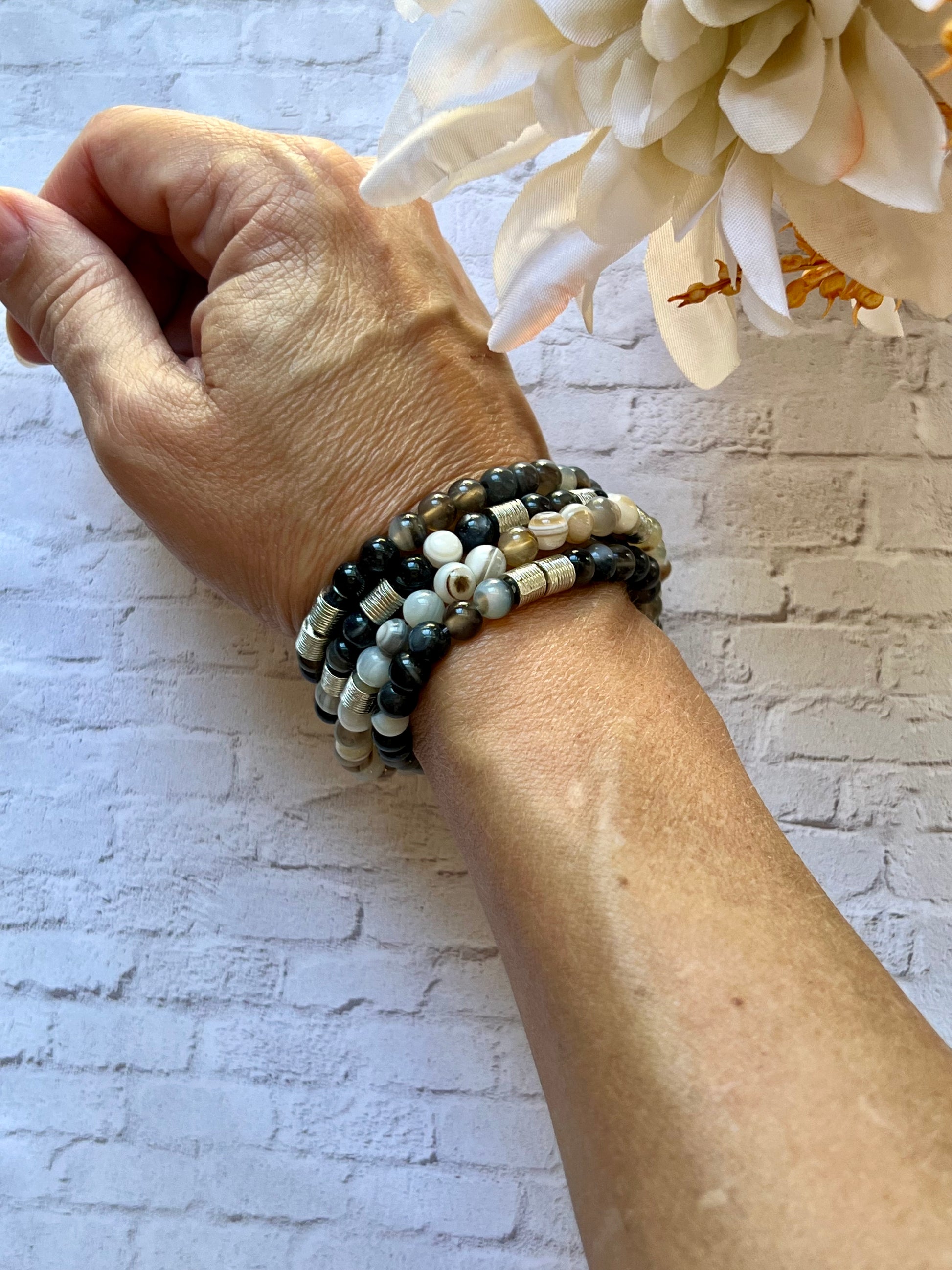 a woman's arm with a flower and two bracelets on it