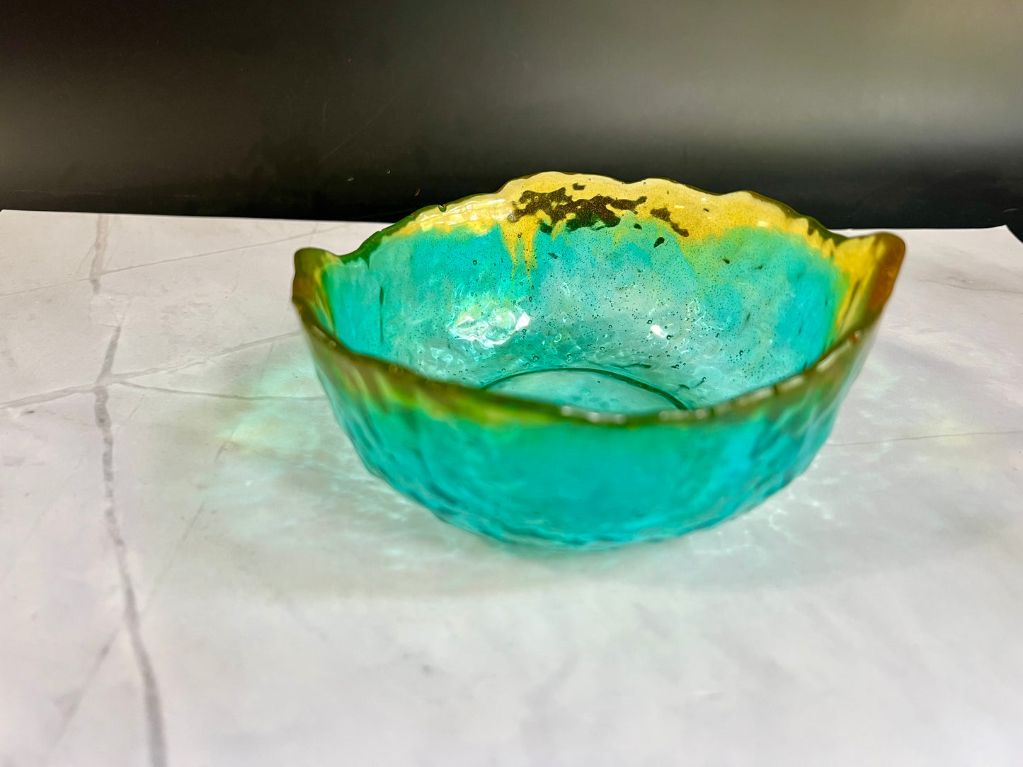 a green and yellow bowl sitting on top of a table