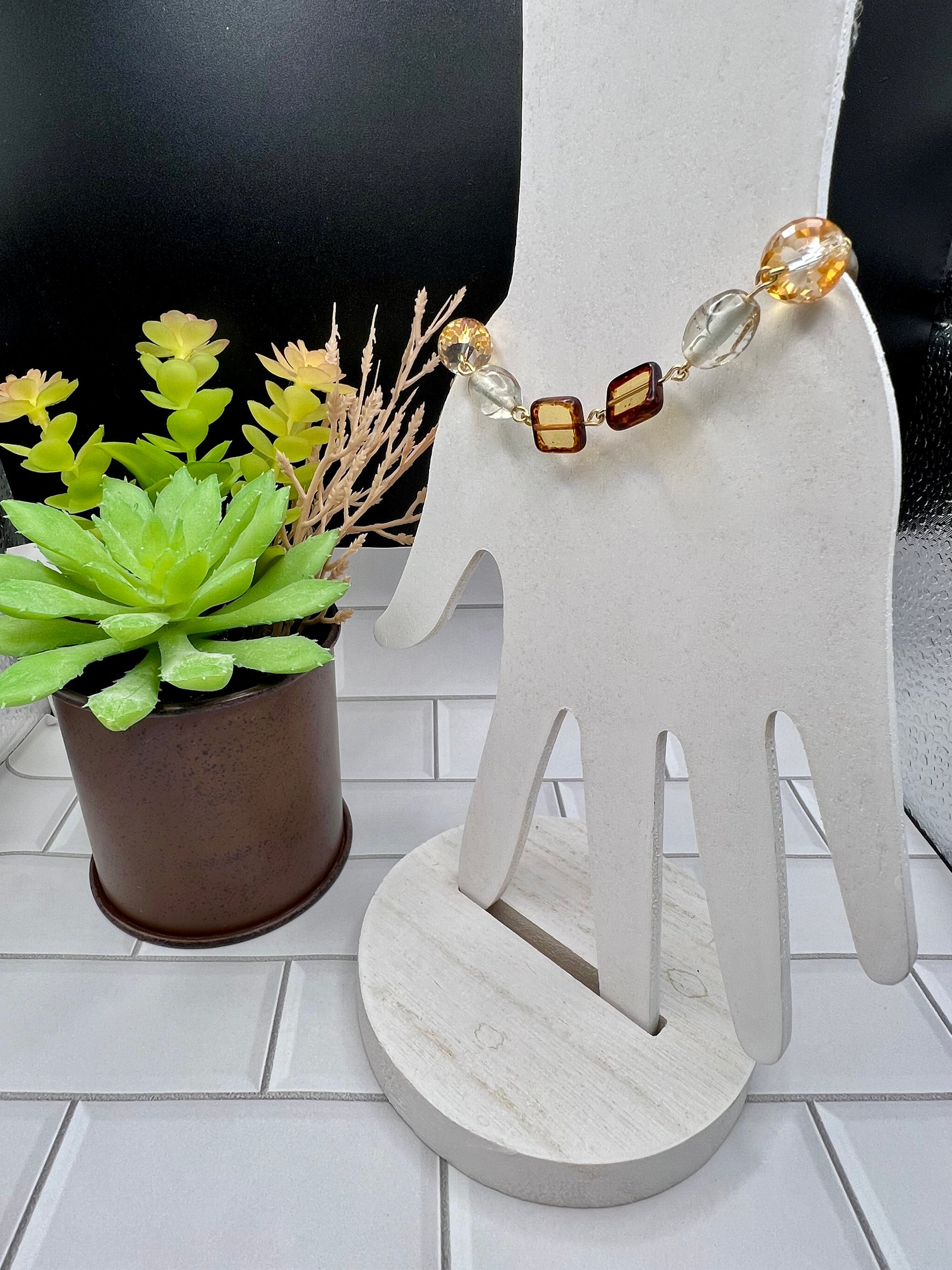 a white rocking chair with a beaded necklace on it