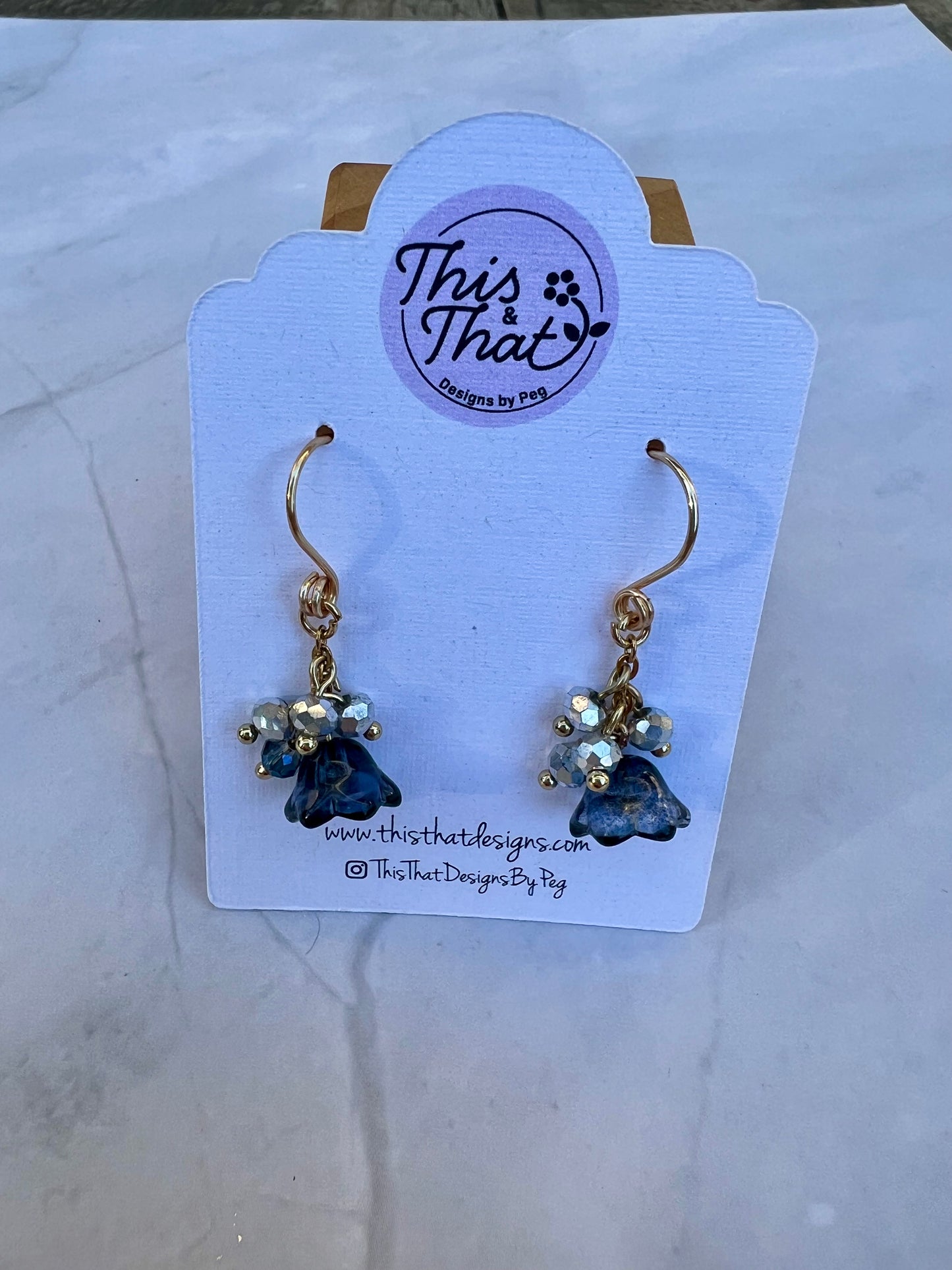 a pair of earrings with blue stones on them