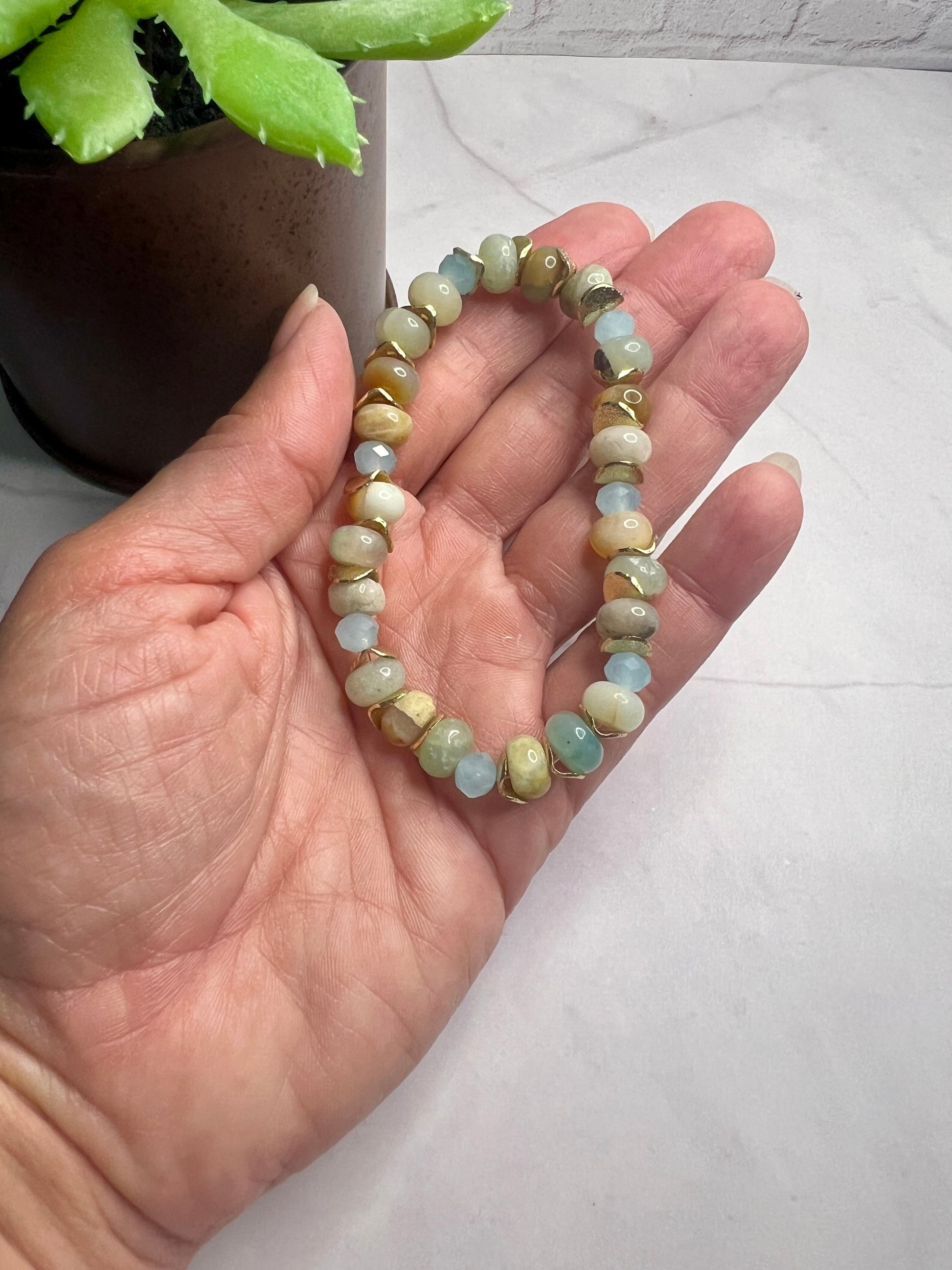 a woman's hand holding a beaded bracelet