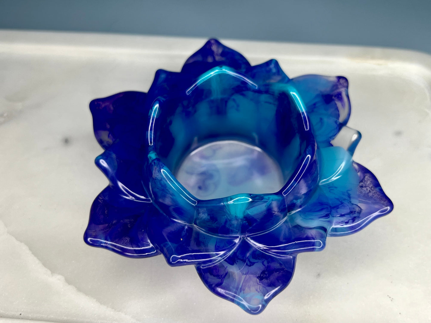 a blue glass flower sitting on top of a white counter