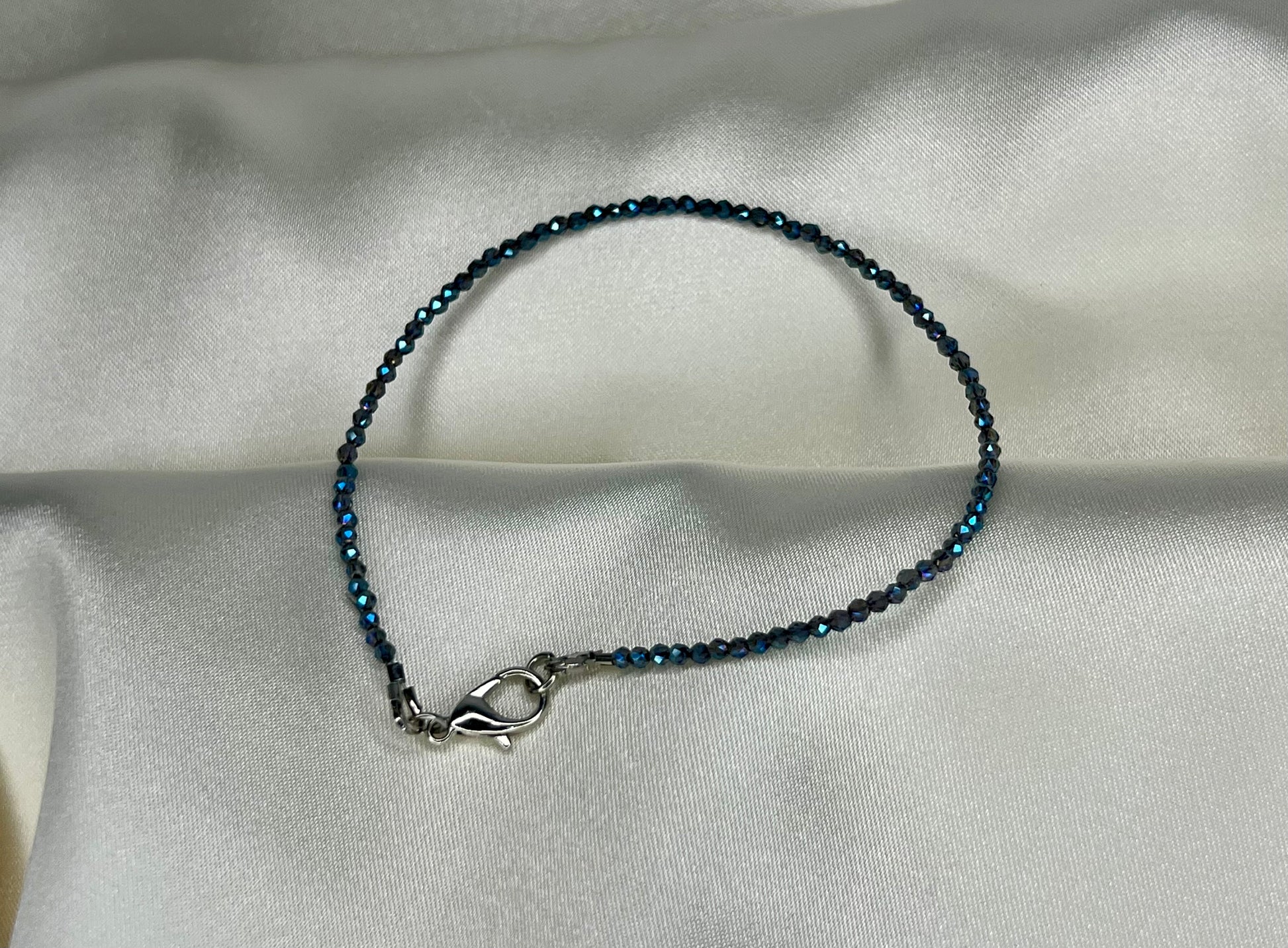 a blue beaded bracelet with a silver clasp