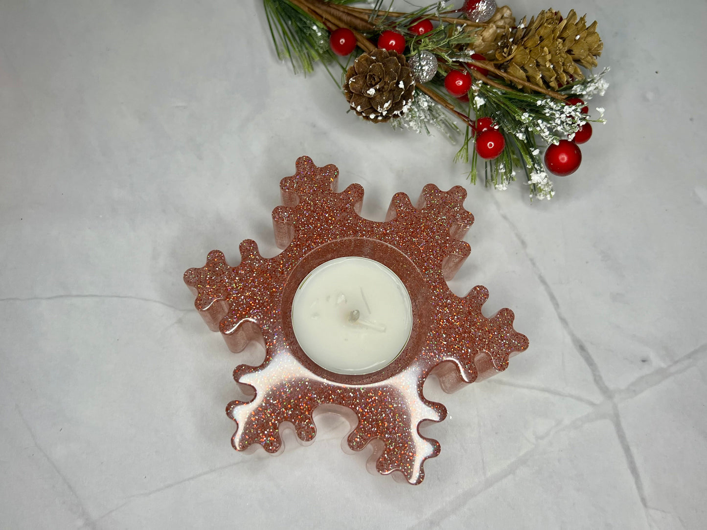 a candle sitting on top of a table next to a snowflake