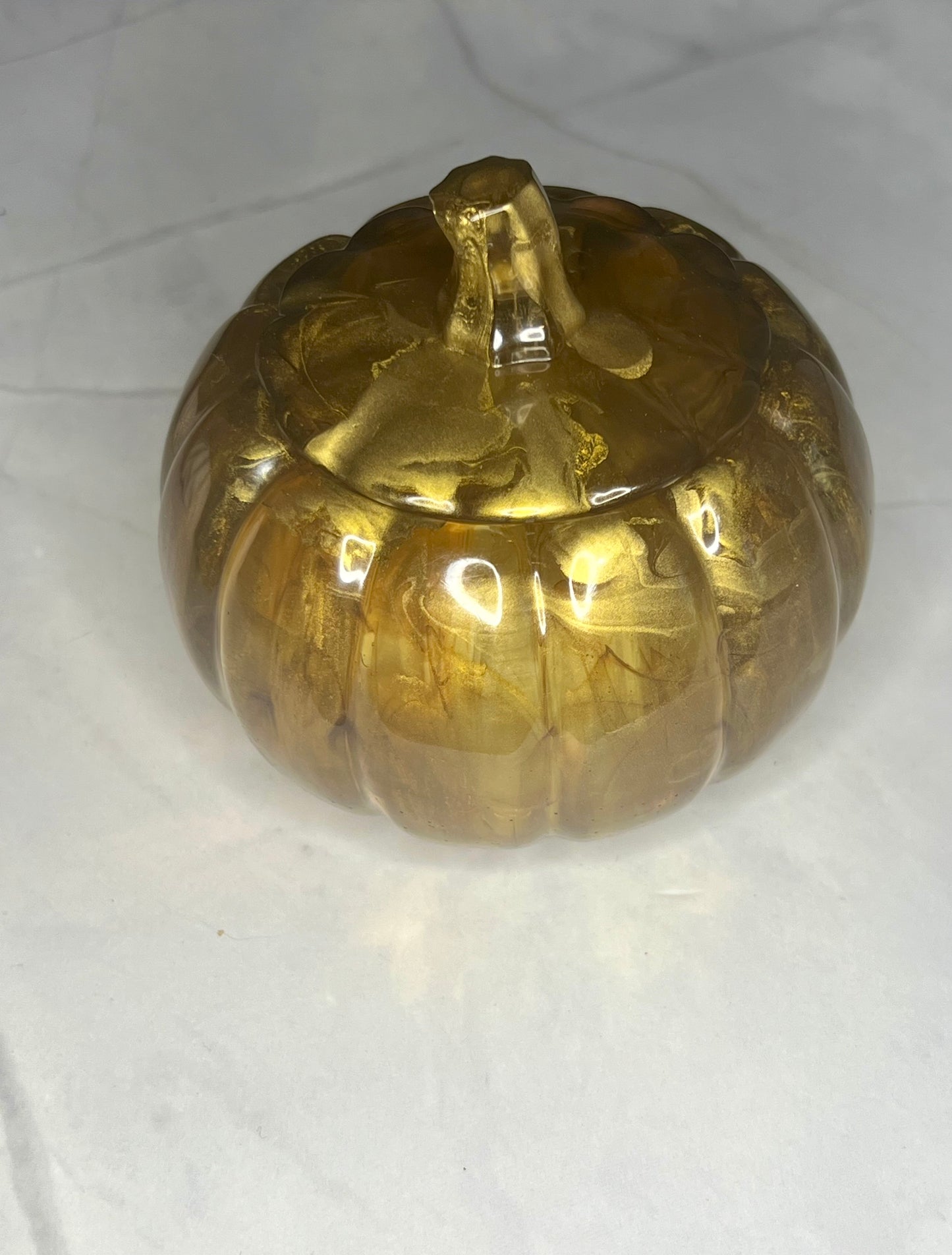 a golden vase sitting on top of a white table