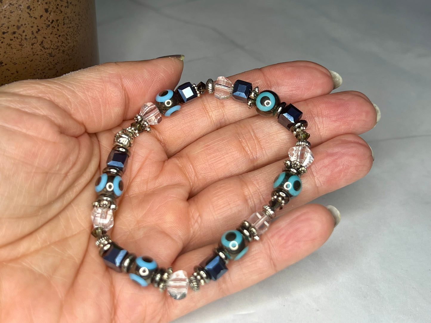 a person holding a bracelet with evil eyes on it