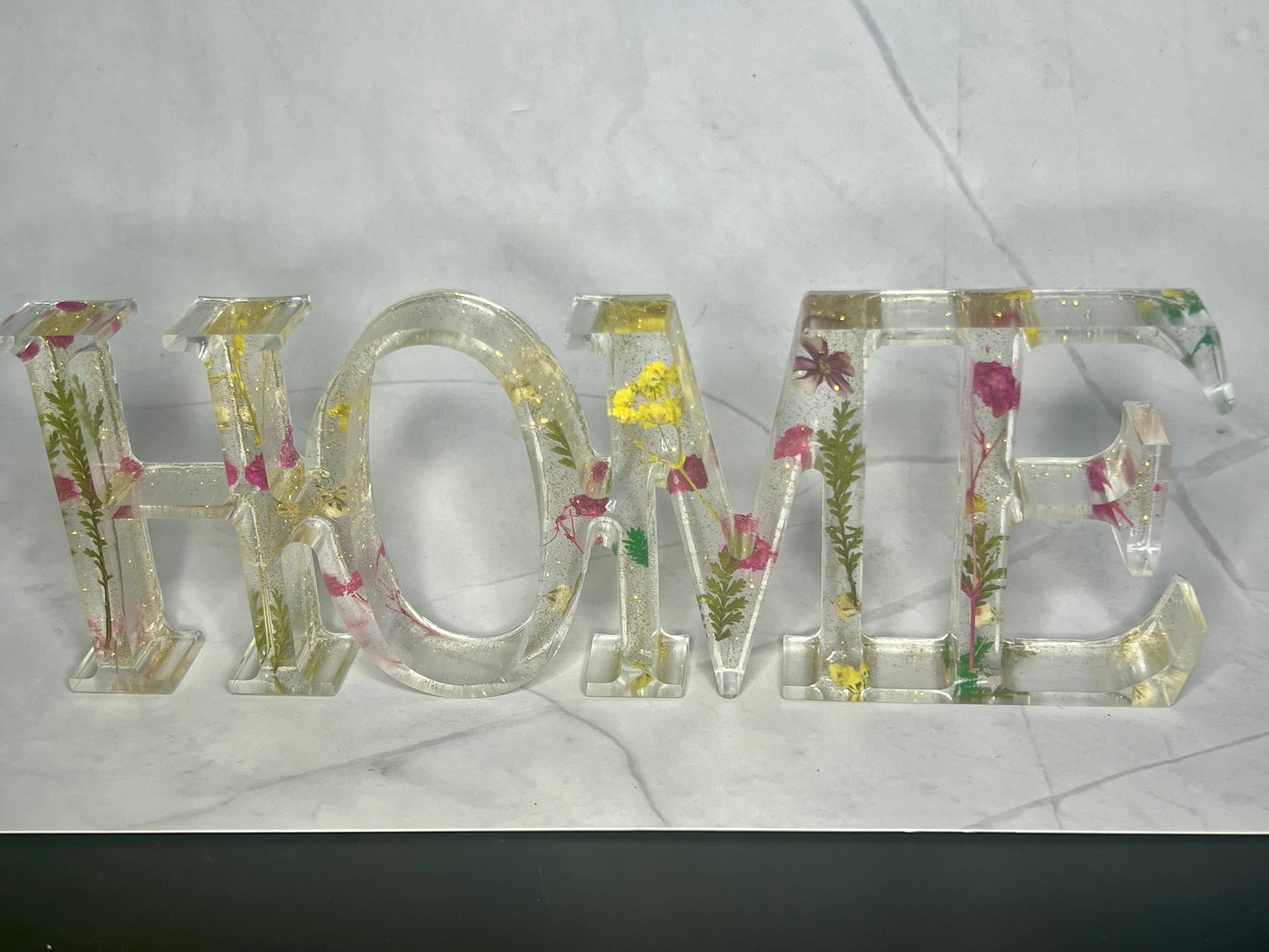 a glass sign that says mom with flowers on it