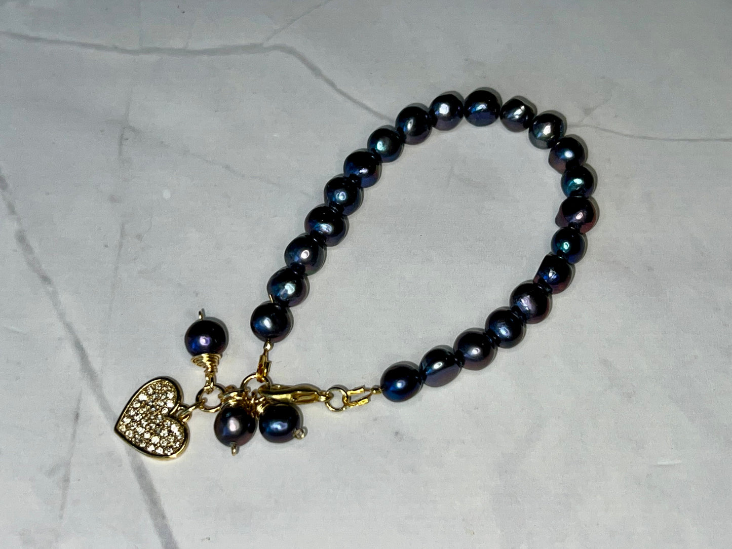 a close up of a bracelet with a heart charm