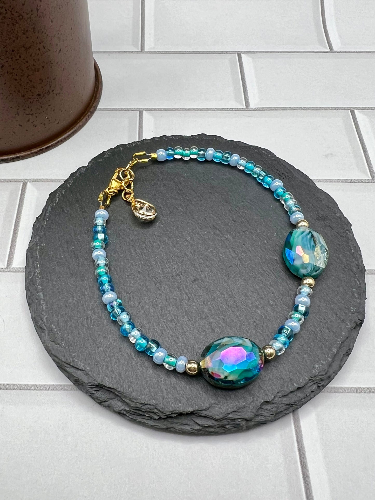 a blue beaded bracelet on a rock