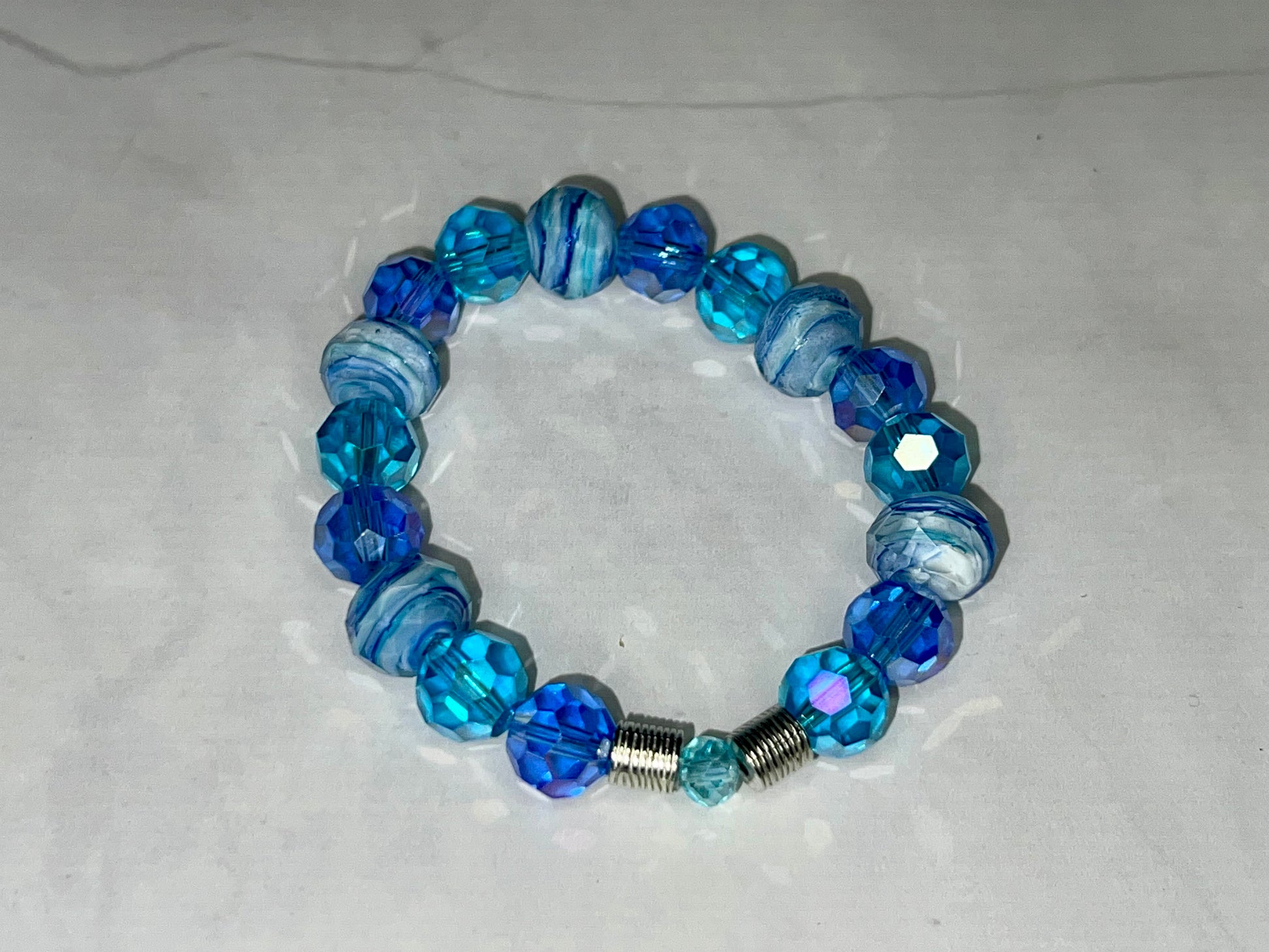 a bracelet with blue glass beads and a silver bead