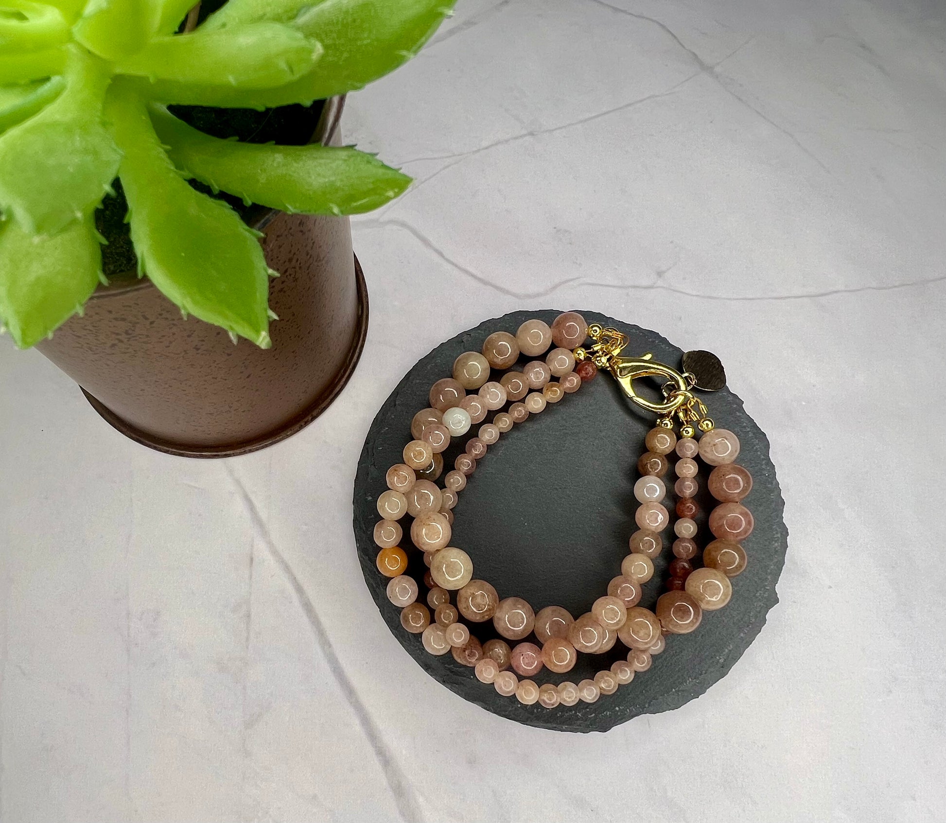 a couple of bracelets sitting next to a potted plant