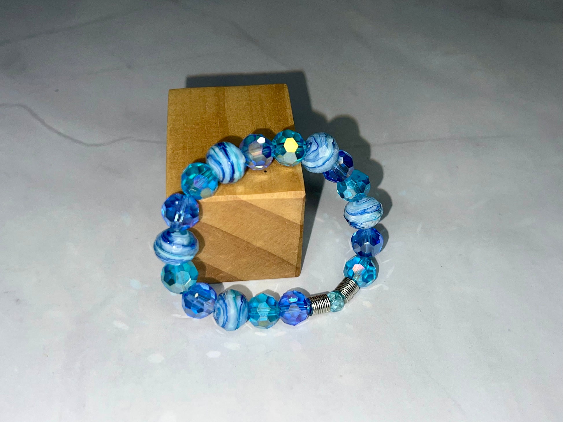 a bracelet with blue glass beads and a wooden box