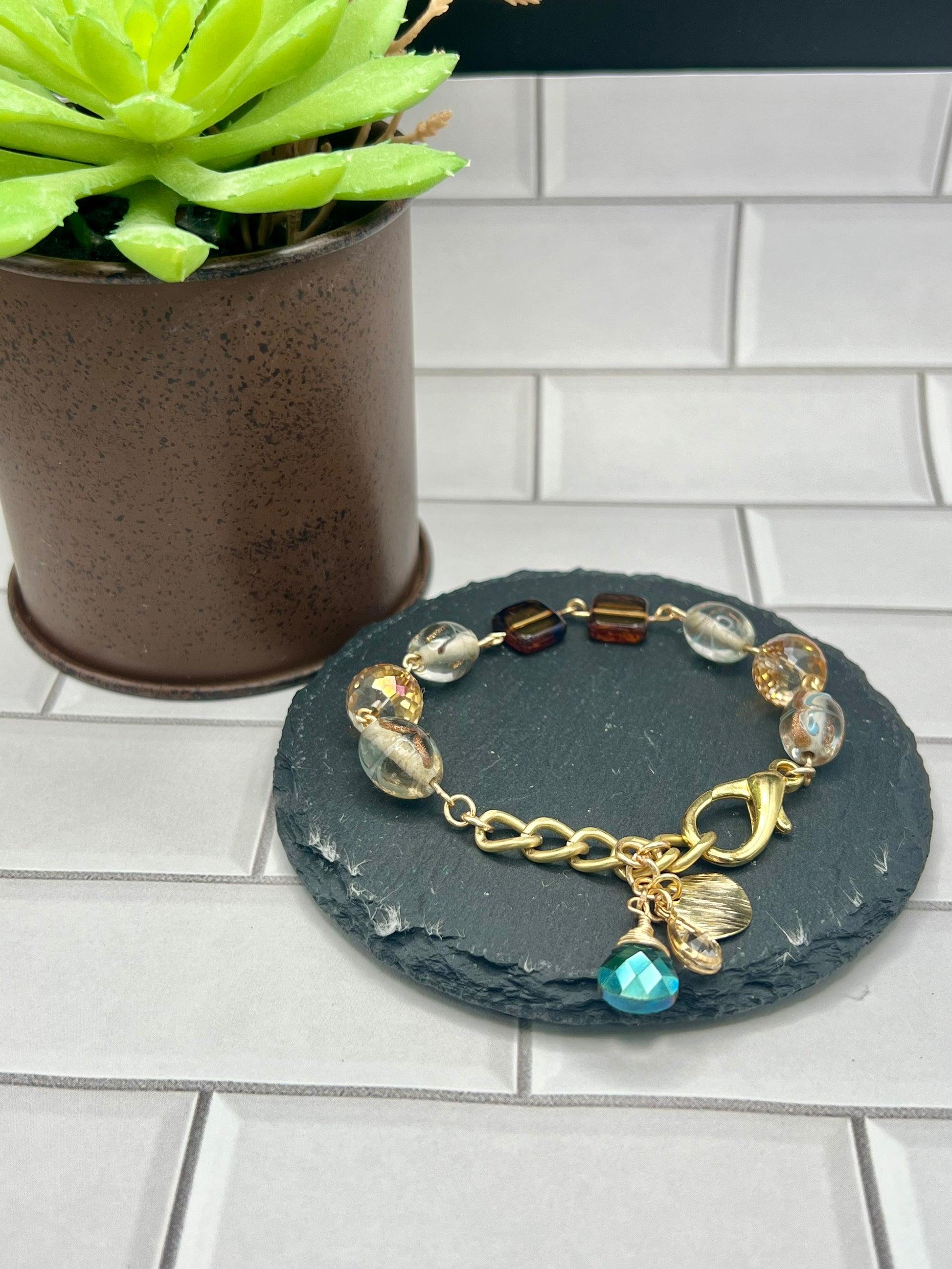 a small potted plant sitting next to a bracelet