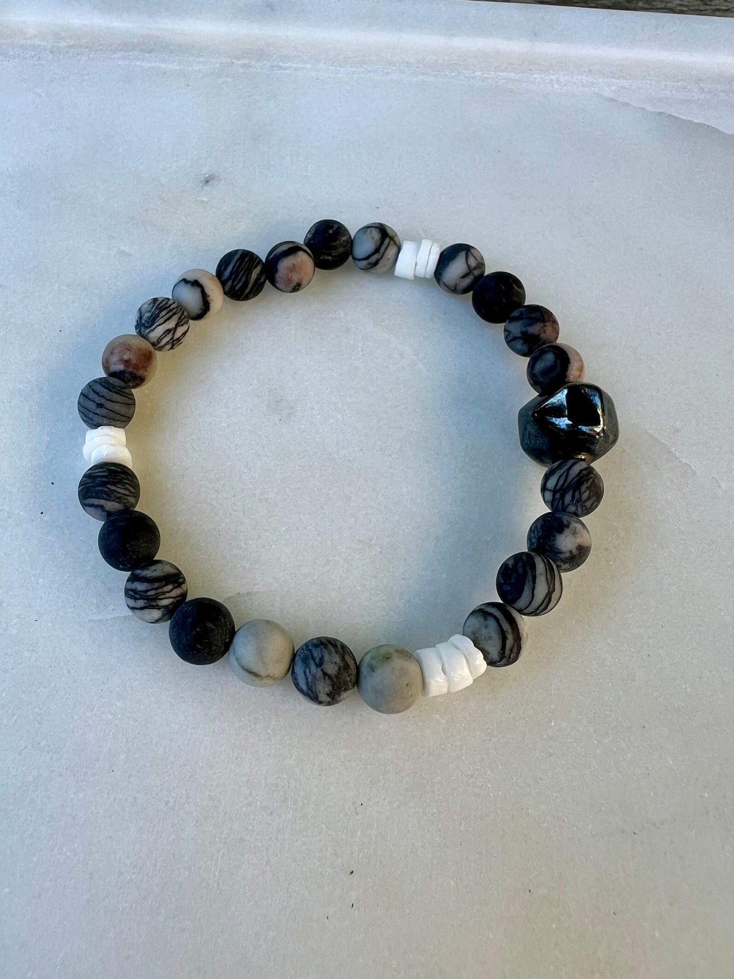 a black and white beaded bracelet on a white surface