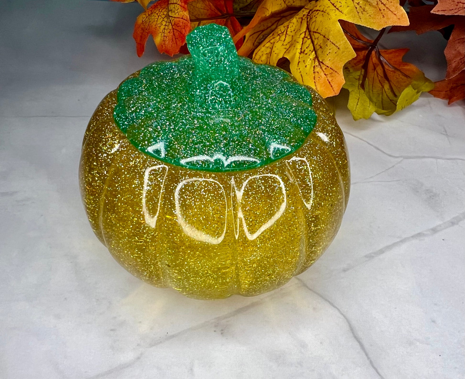 a green pumpkin with a face drawn on it