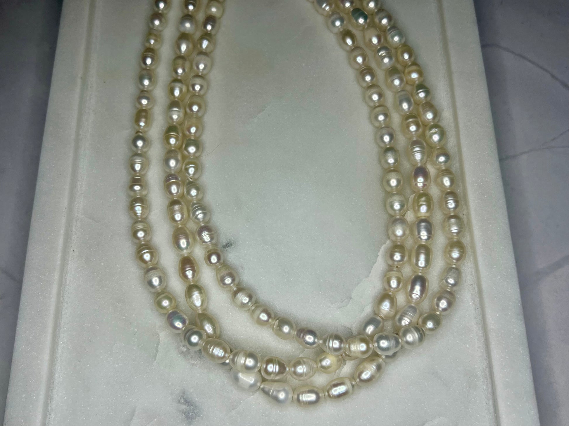 a three strand pearl necklace in a box