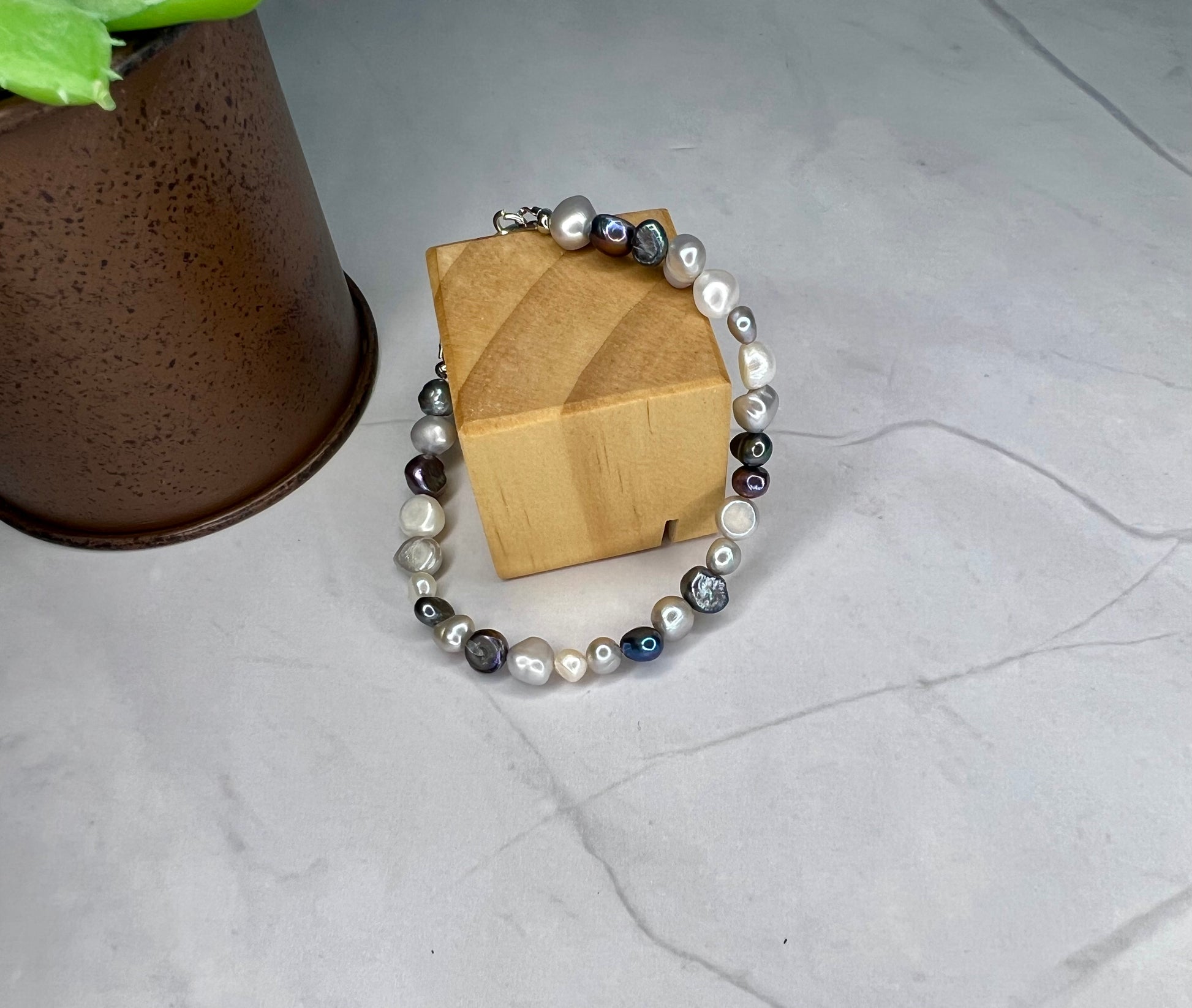 a bracelet with pearls and a wooden box