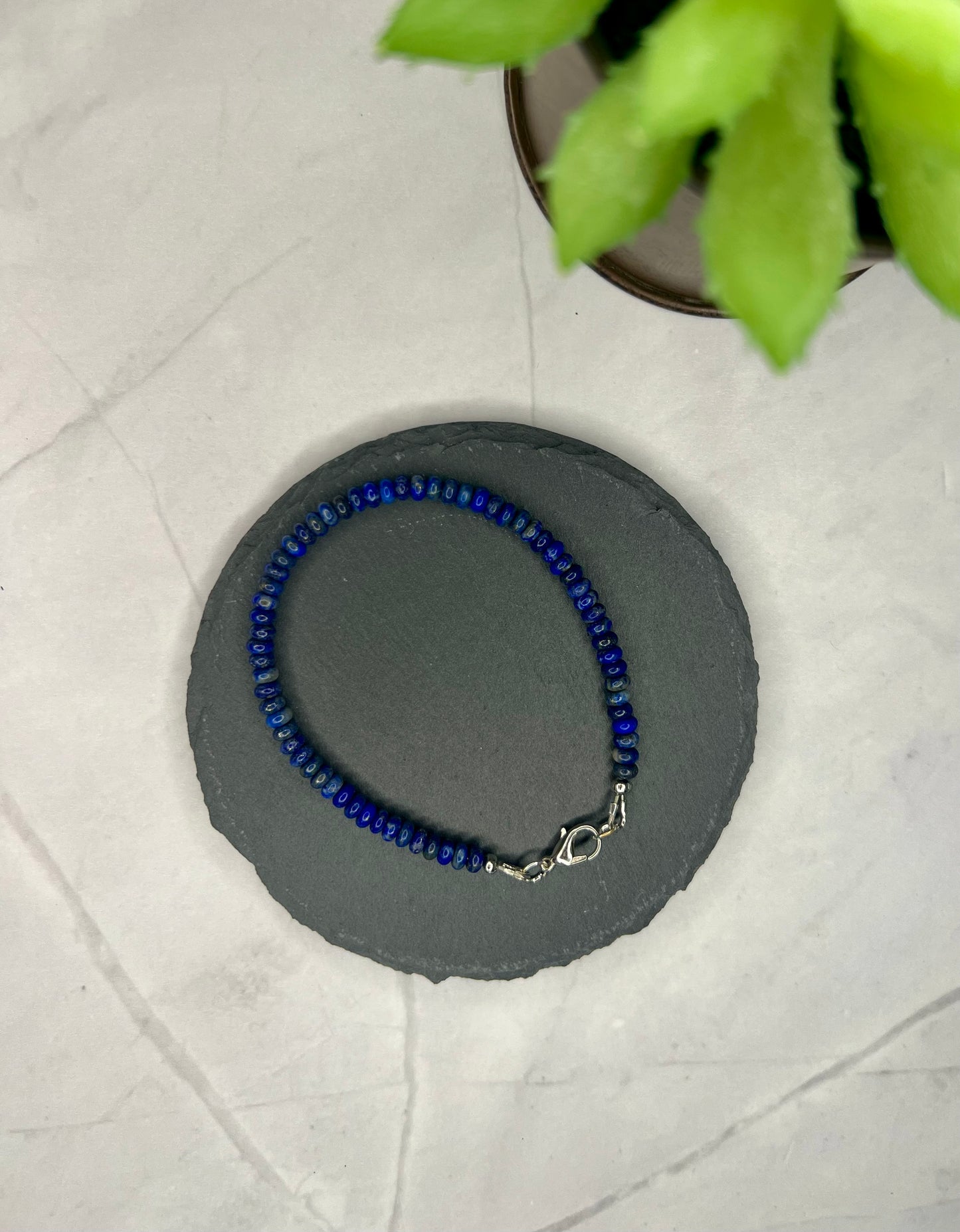 a blue beaded bracelet sitting on top of a table