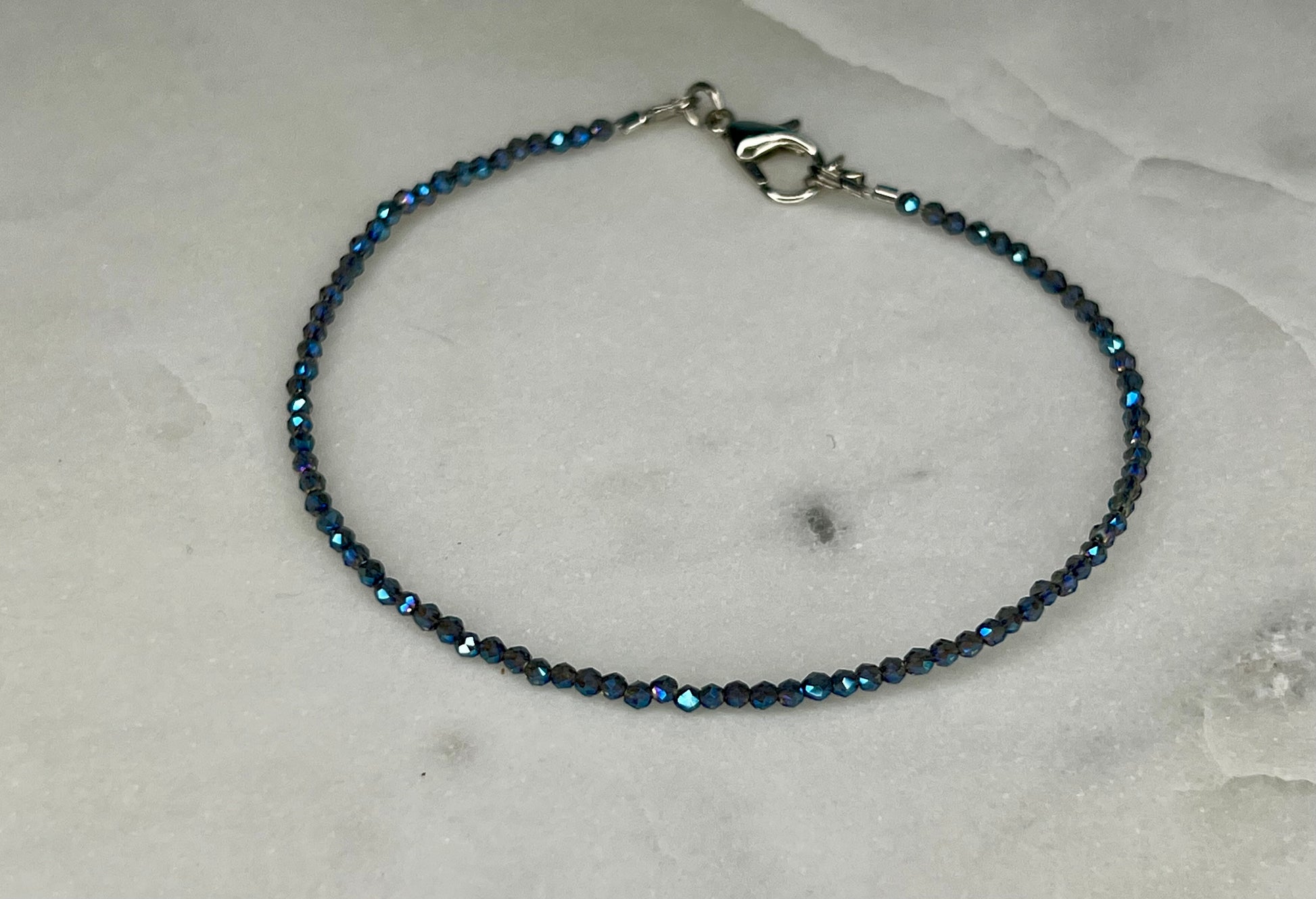 a blue beaded bracelet on a marble surface