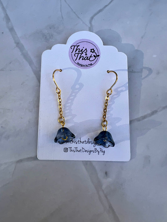 a pair of earrings with a chain hanging from it