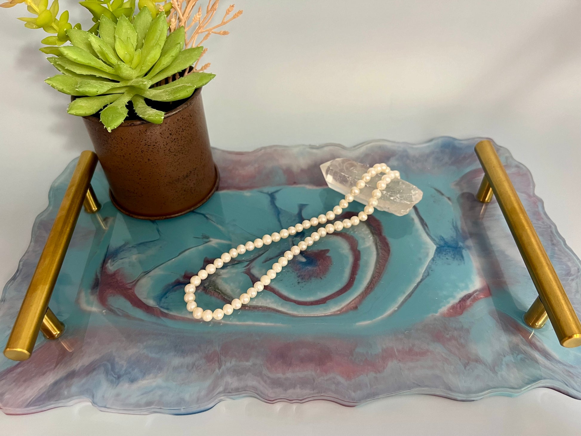 a glass tray with a beaded necklace on it