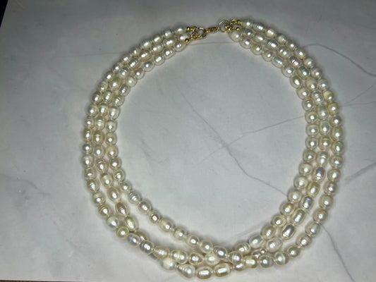 a three strand pearl necklace with a gold clasp