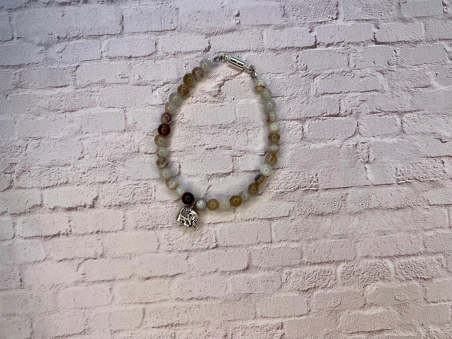 a white brick wall with a bracelet on it