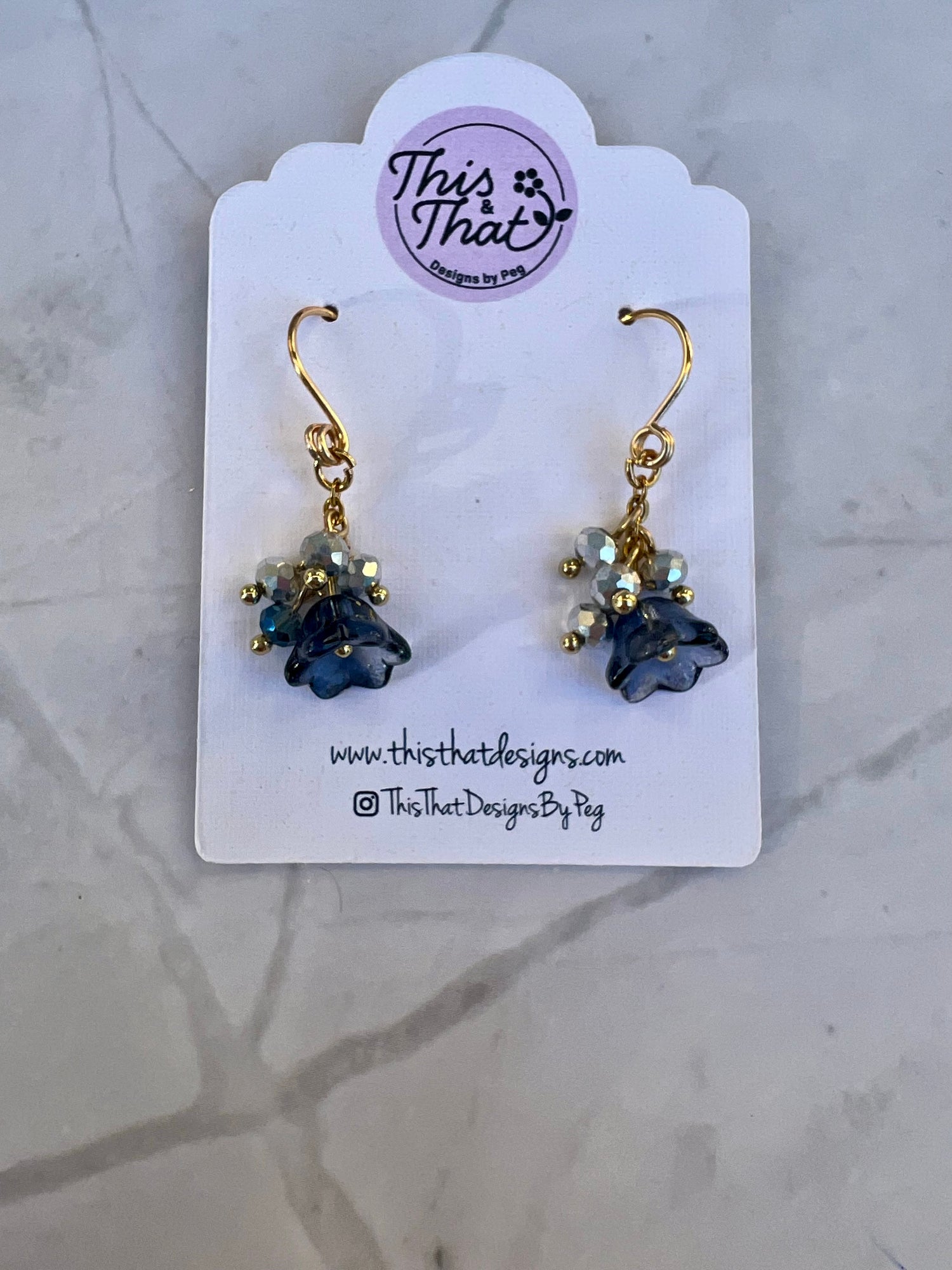 a pair of blue and gold earrings on a card