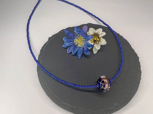 a blue beaded necklace with flowers on it