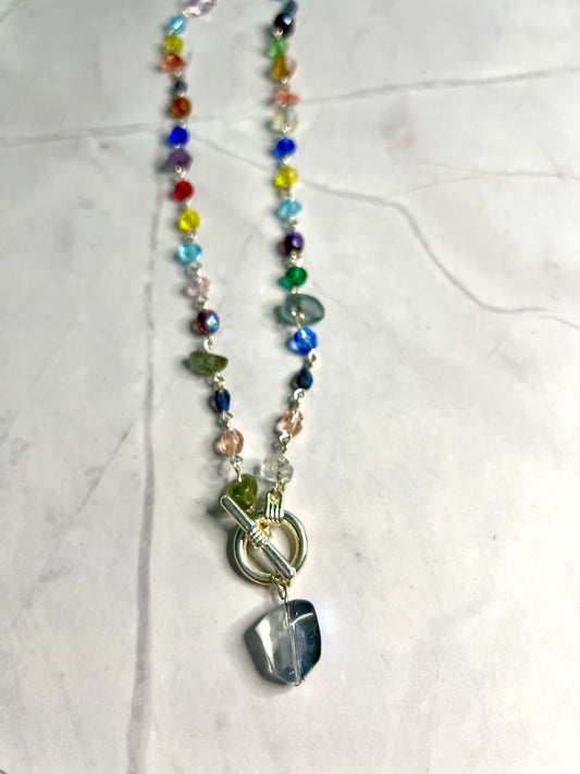 a multicolored beaded necklace on a marble surface