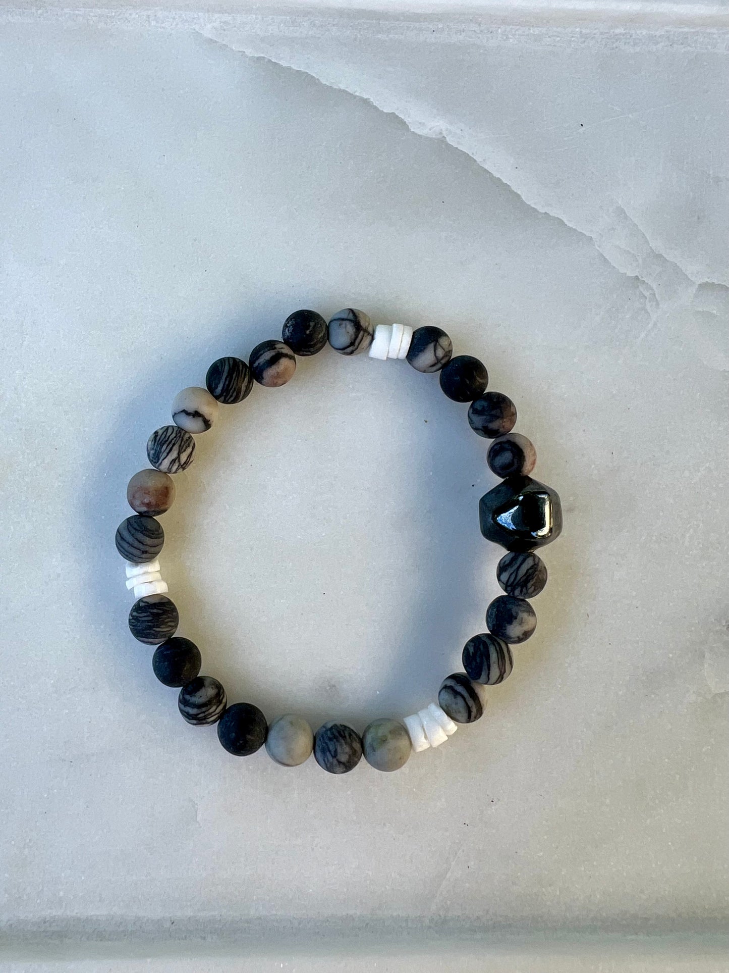 a black and white beaded bracelet on a white surface