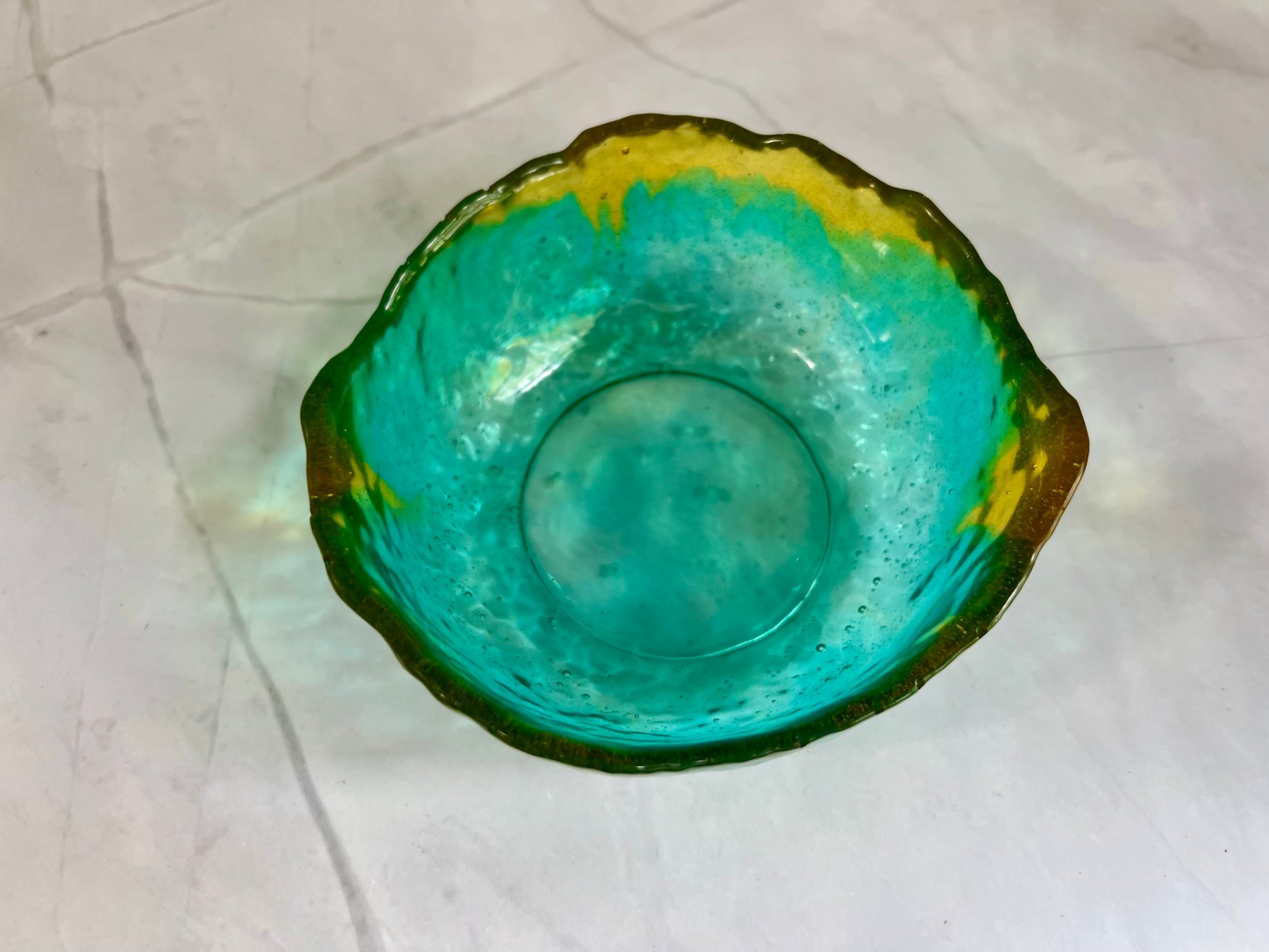 a green bowl sitting on top of a white counter