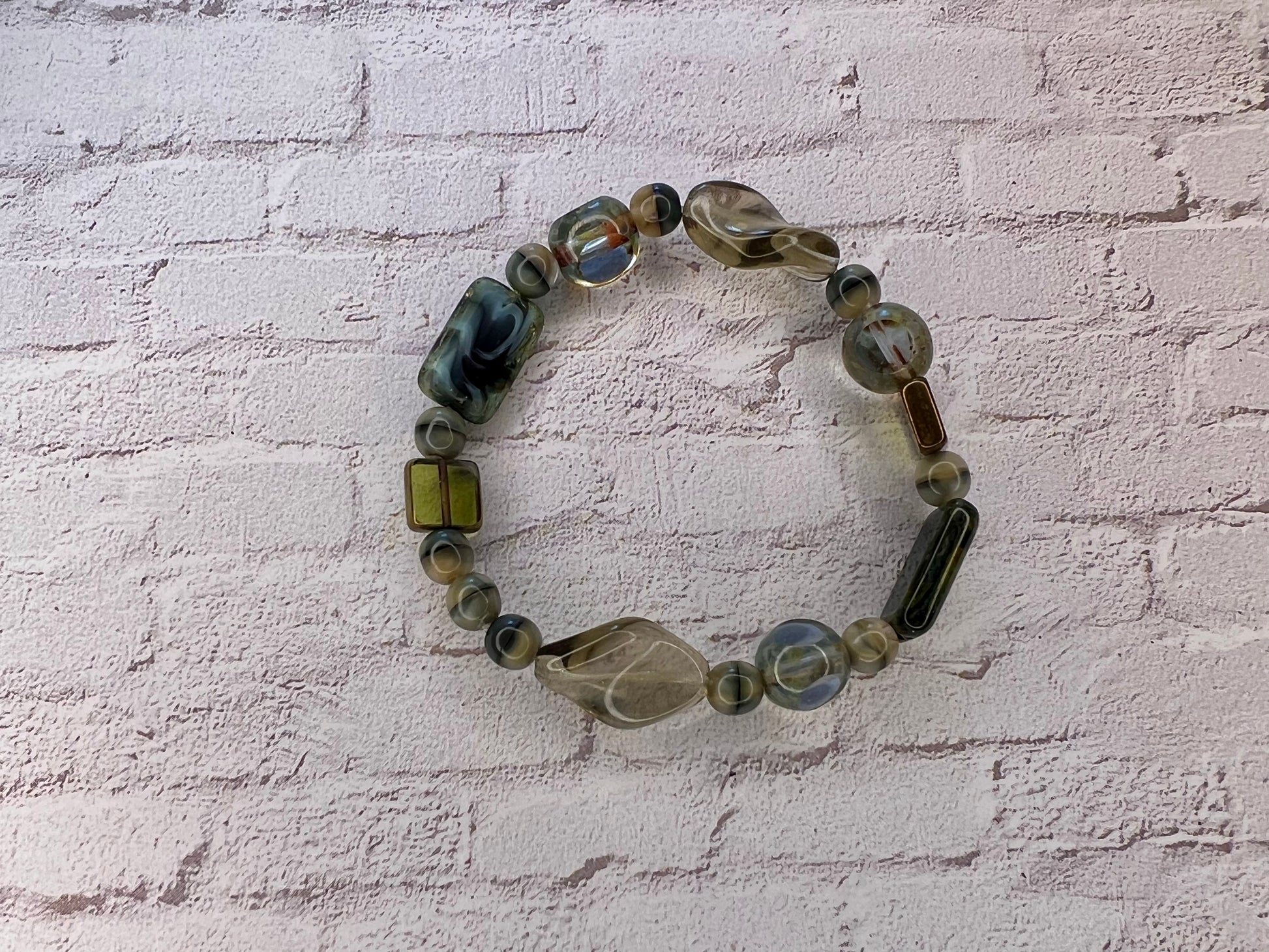 a bracelet made of glass beads on a brick wall